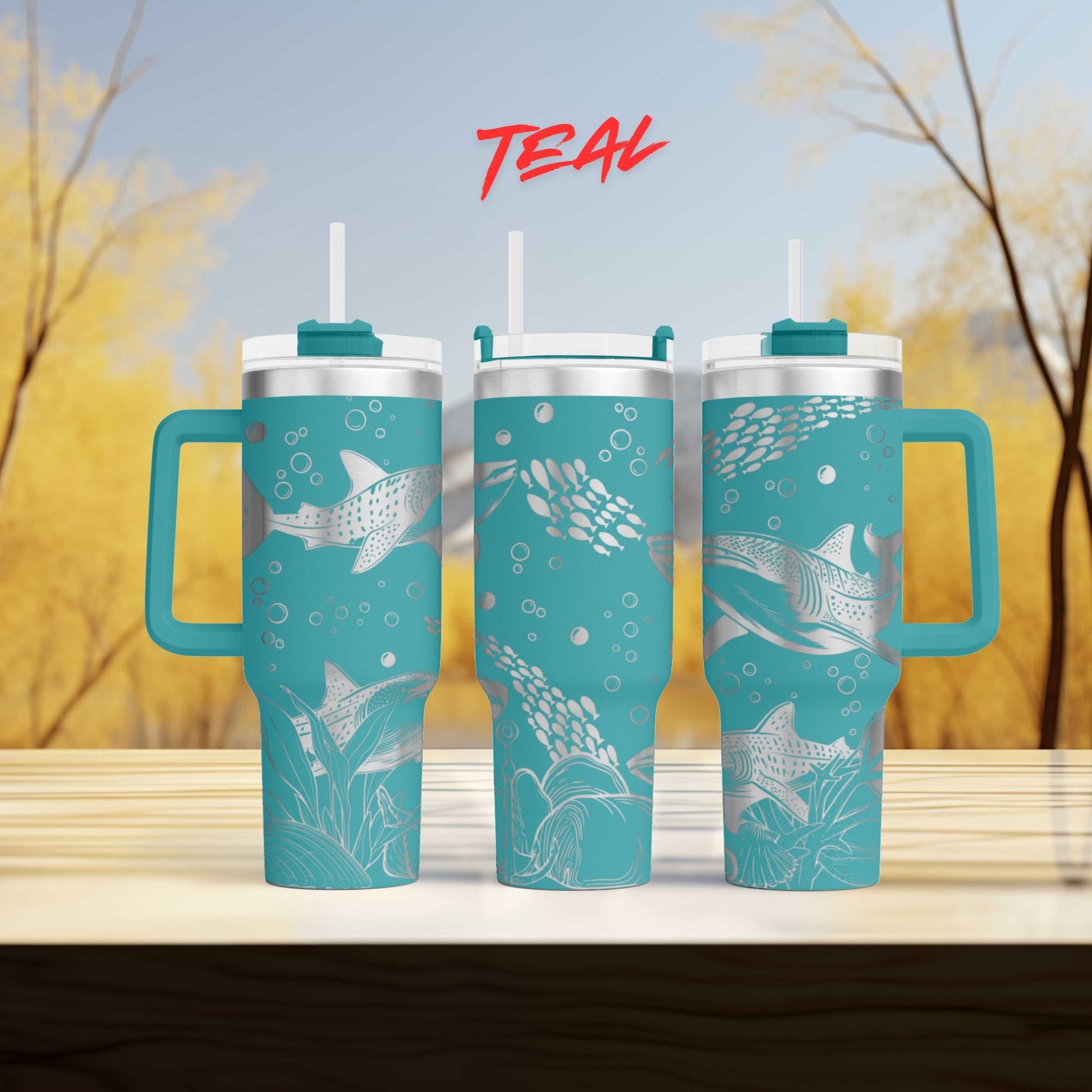three teal travel mugs sitting on top of a wooden table