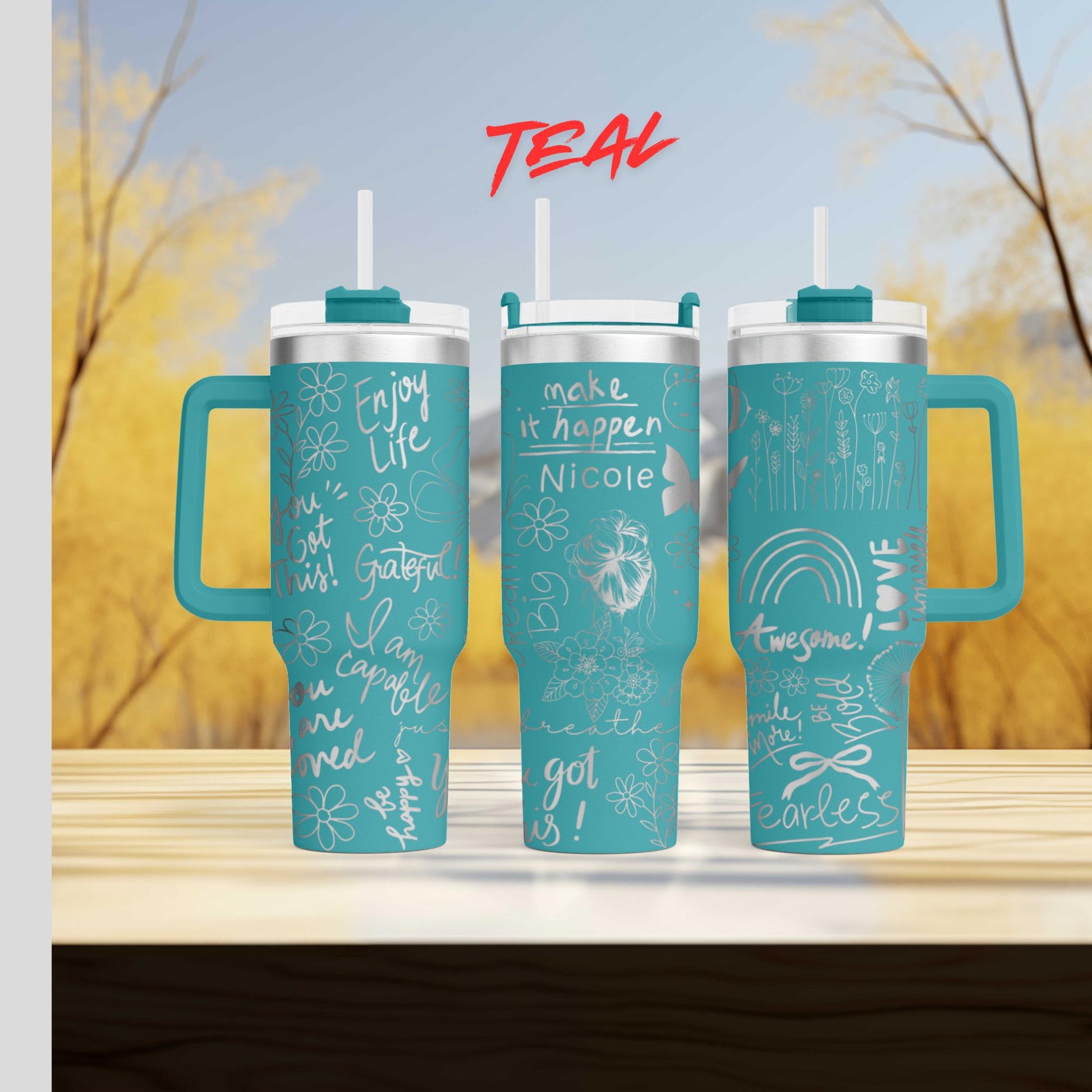 a set of three teal colored travel mugs sitting on top of a wooden