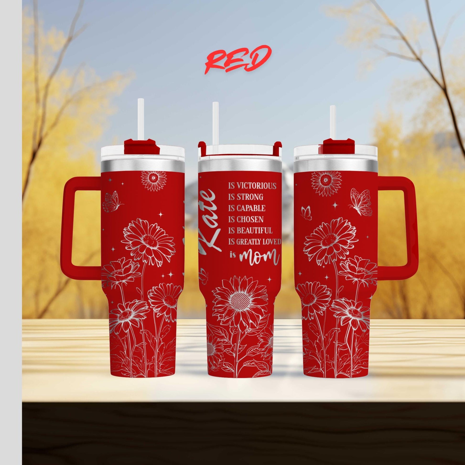 three red travel mugs sitting on top of a wooden table