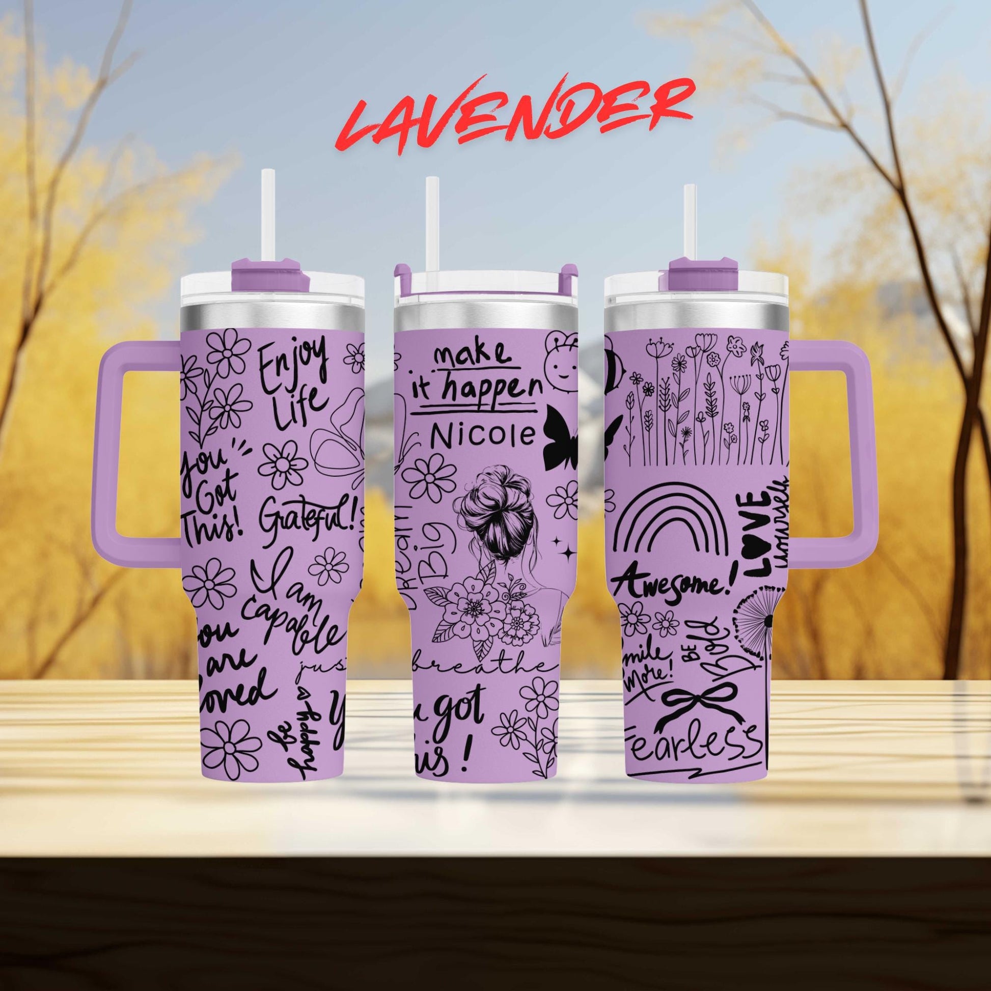three travel mugs with designs on them sitting on a table