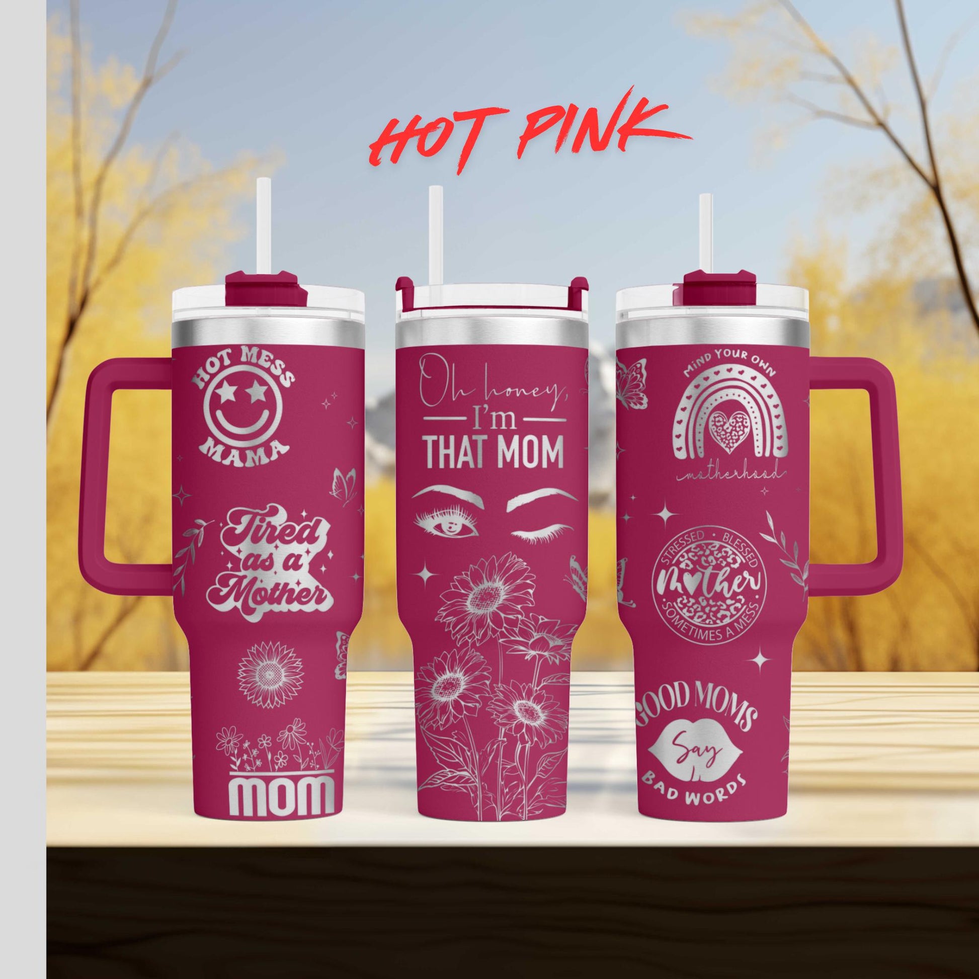 three pink travel mugs sitting on top of a wooden table