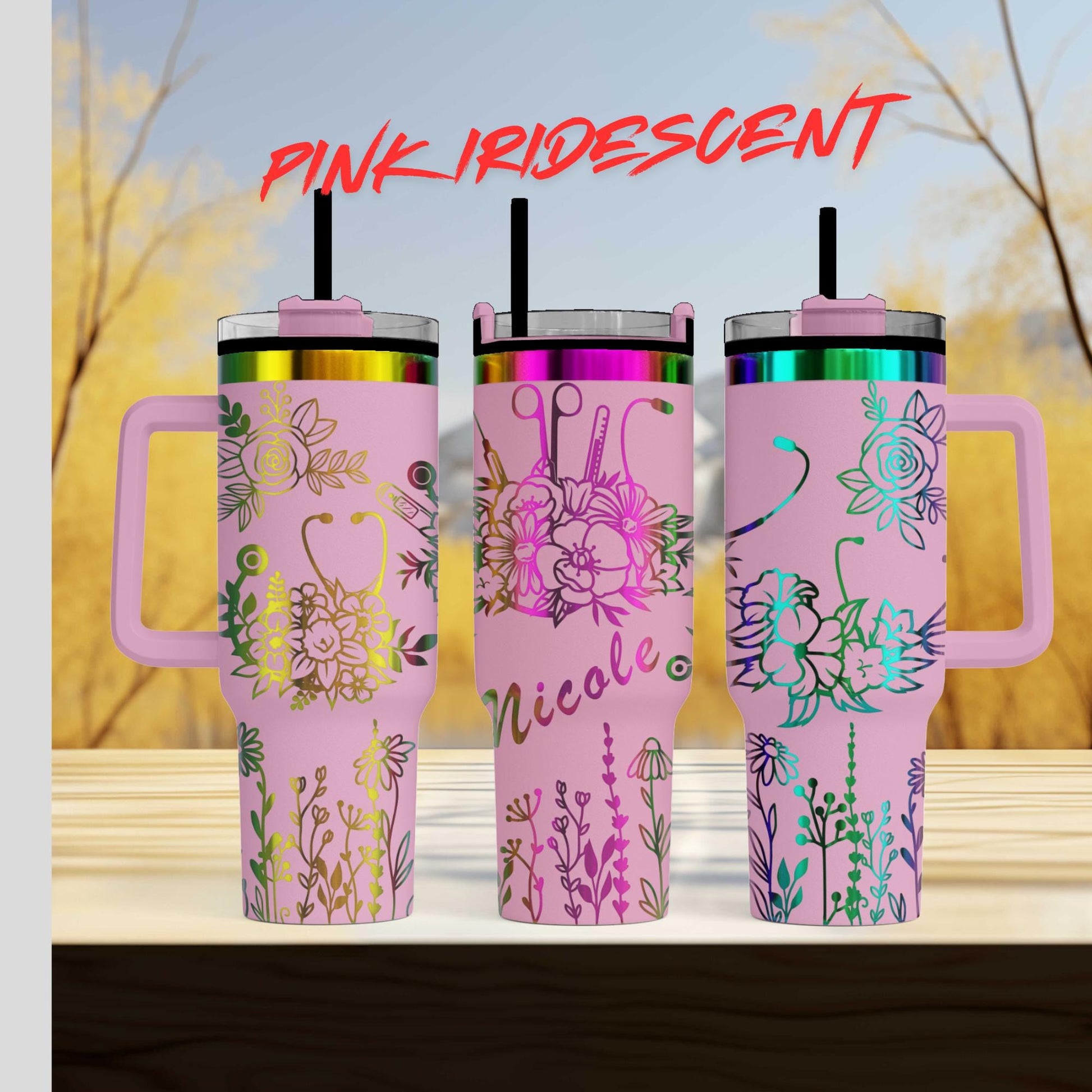 three pink travel mugs sitting on top of a wooden table