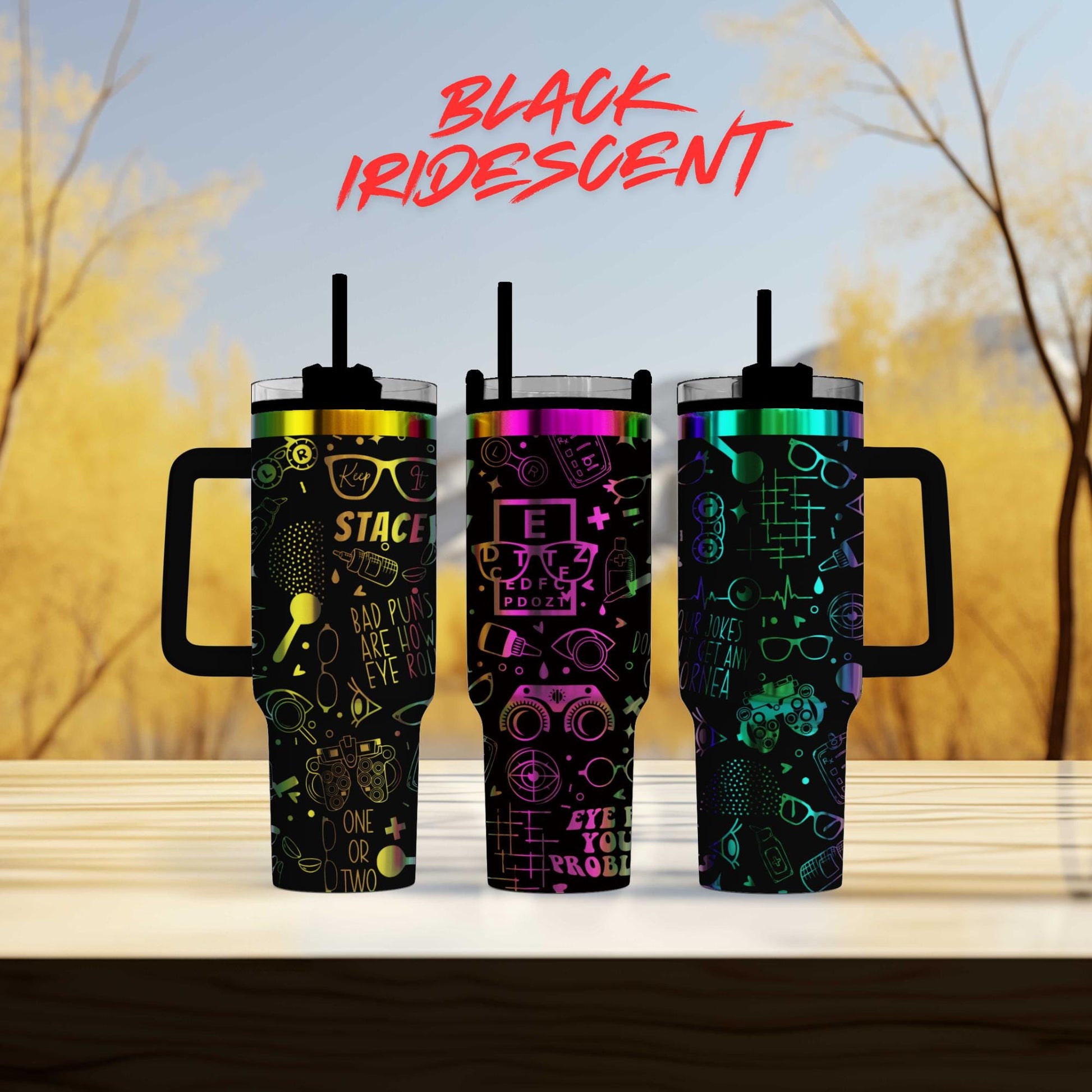 Three colorful, patterned tumblers with handles, set against a blurred natural background.