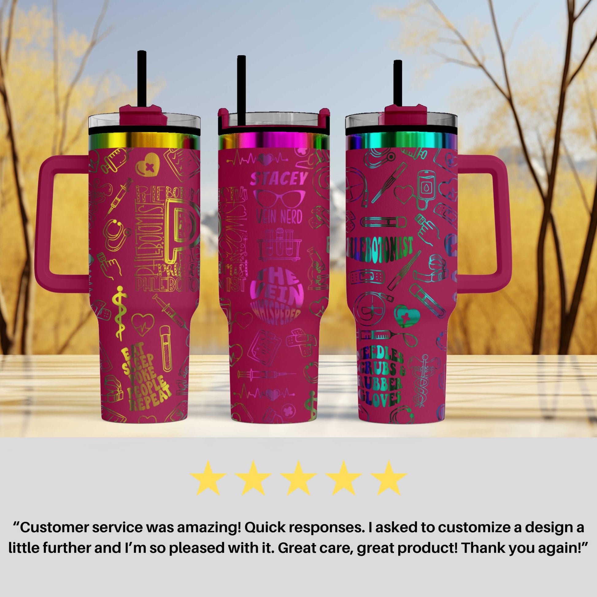 three pink tumblers with colorful designs and straws, placed on a wooden surface against a blurred background of trees.