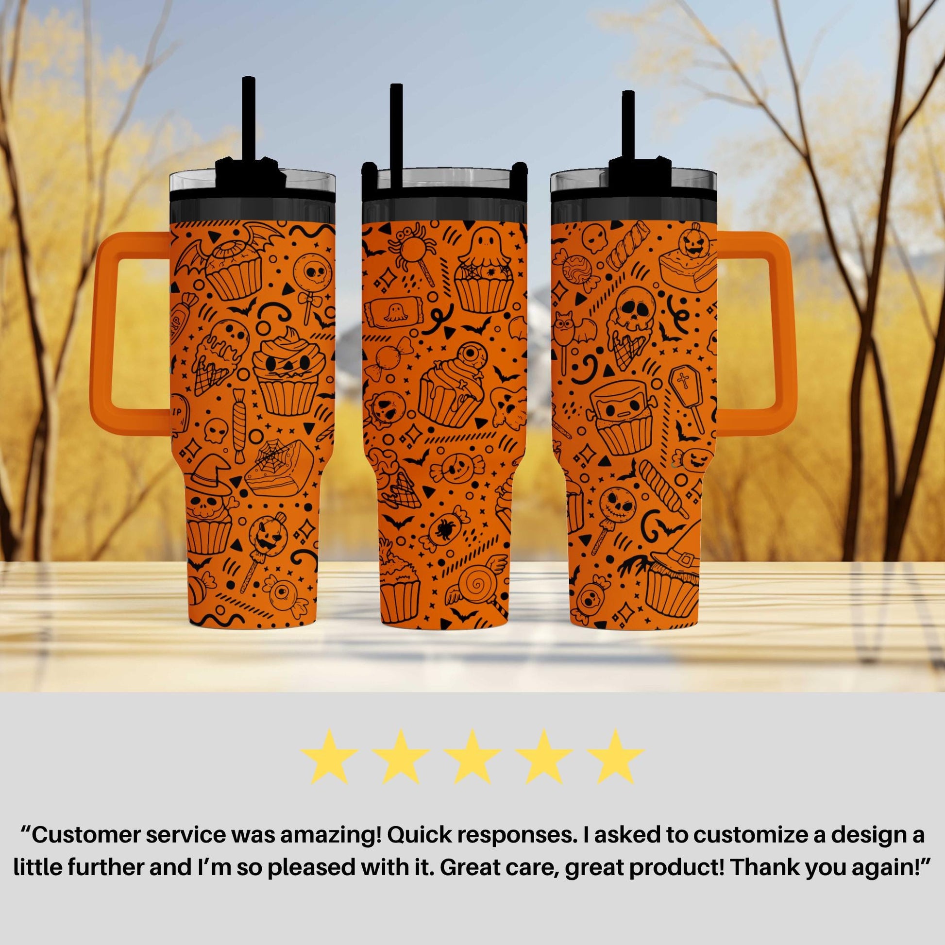 three orange tumblers with a Halloween-themed design, including skulls, bats, and cupcakes, placed on a wooden surface against a blurred background of trees.