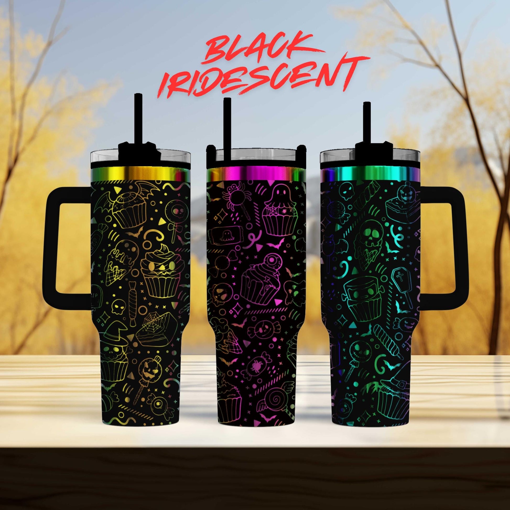 three colorful, patterned insulated tumblers with handles, arranged on a wooden surface against a blurred background of trees.