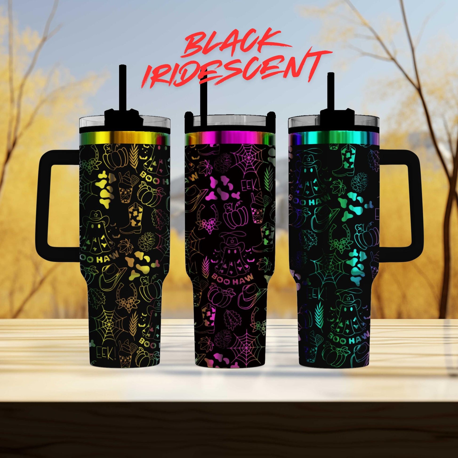 three colorful, patterned tumblers with handles, arranged on a wooden surface against a blurred background of trees.