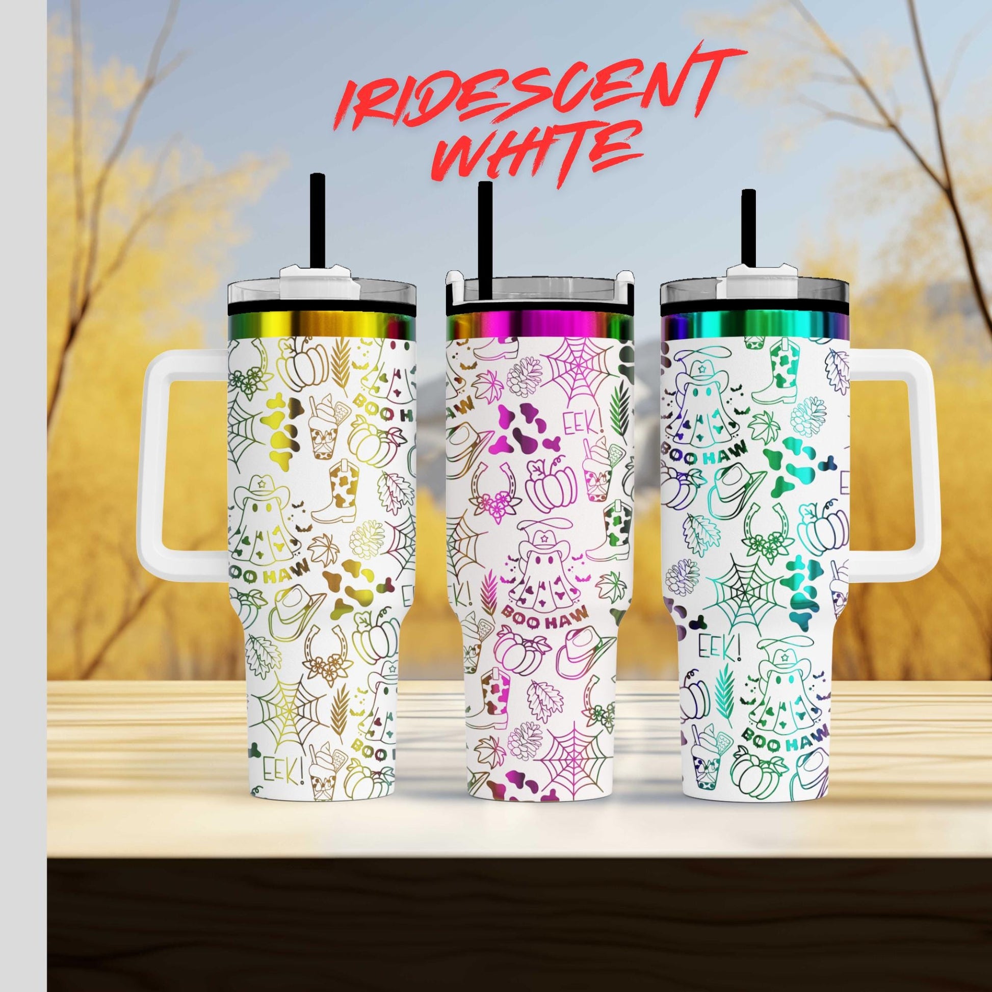 Three colorful, patterned insulated tumblers with handles, arranged on a wooden surface against a blurred background of trees.