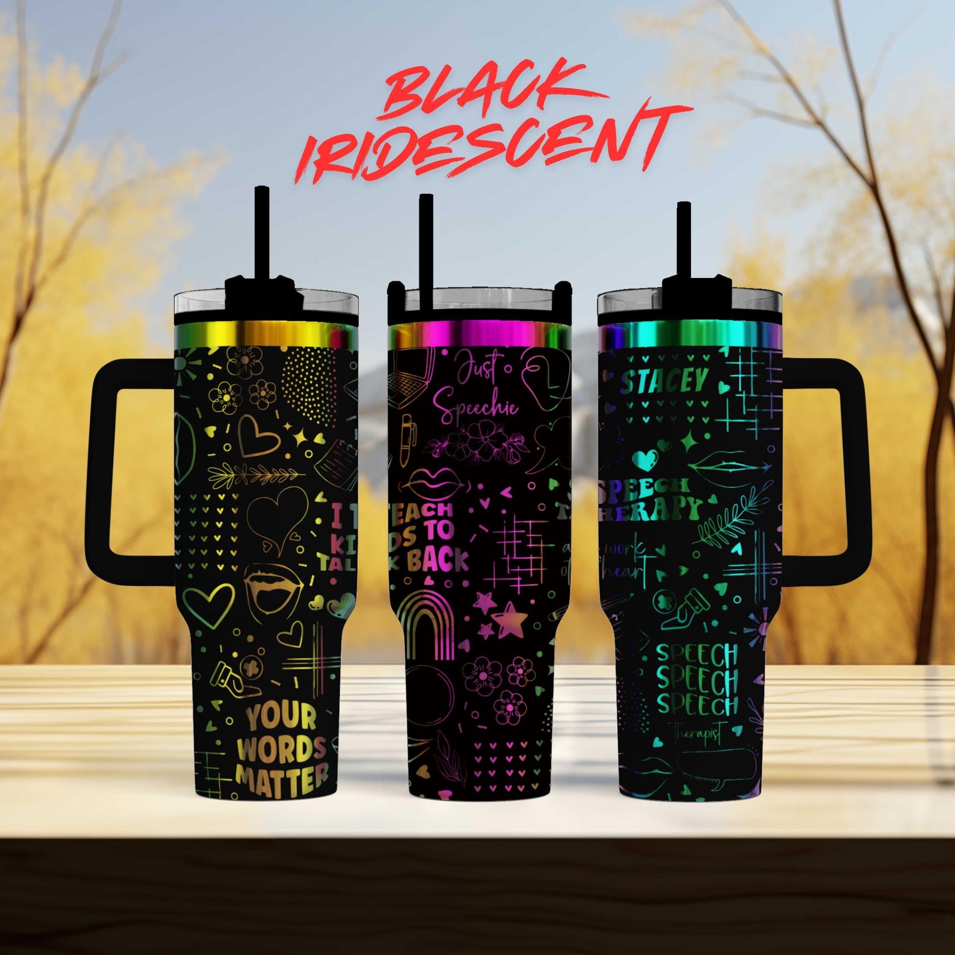 three colorful, patterned tumblers with handles, arranged in a row on a wooden surface.