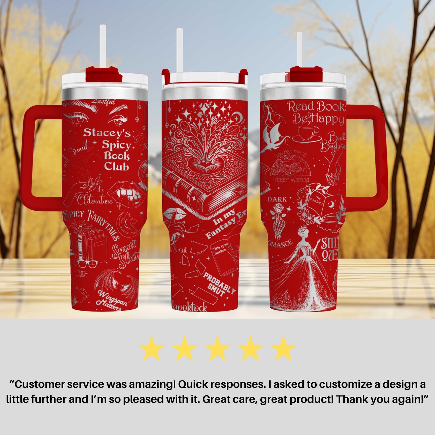 three red tumblers with white text and illustrations on them, placed on a wooden surface against a blurred background of trees.