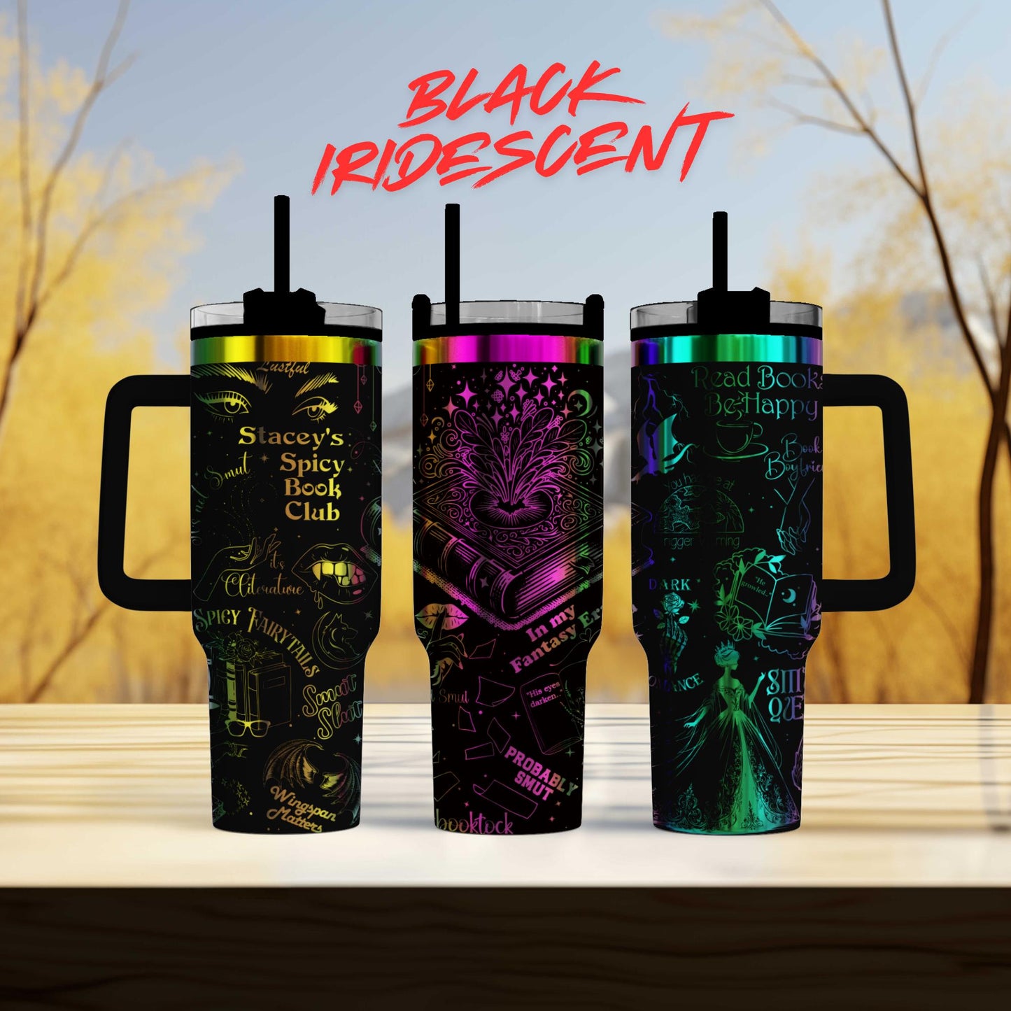 three colorful, patterned tumblers with handles, arranged on a wooden surface against a blurred background of trees.