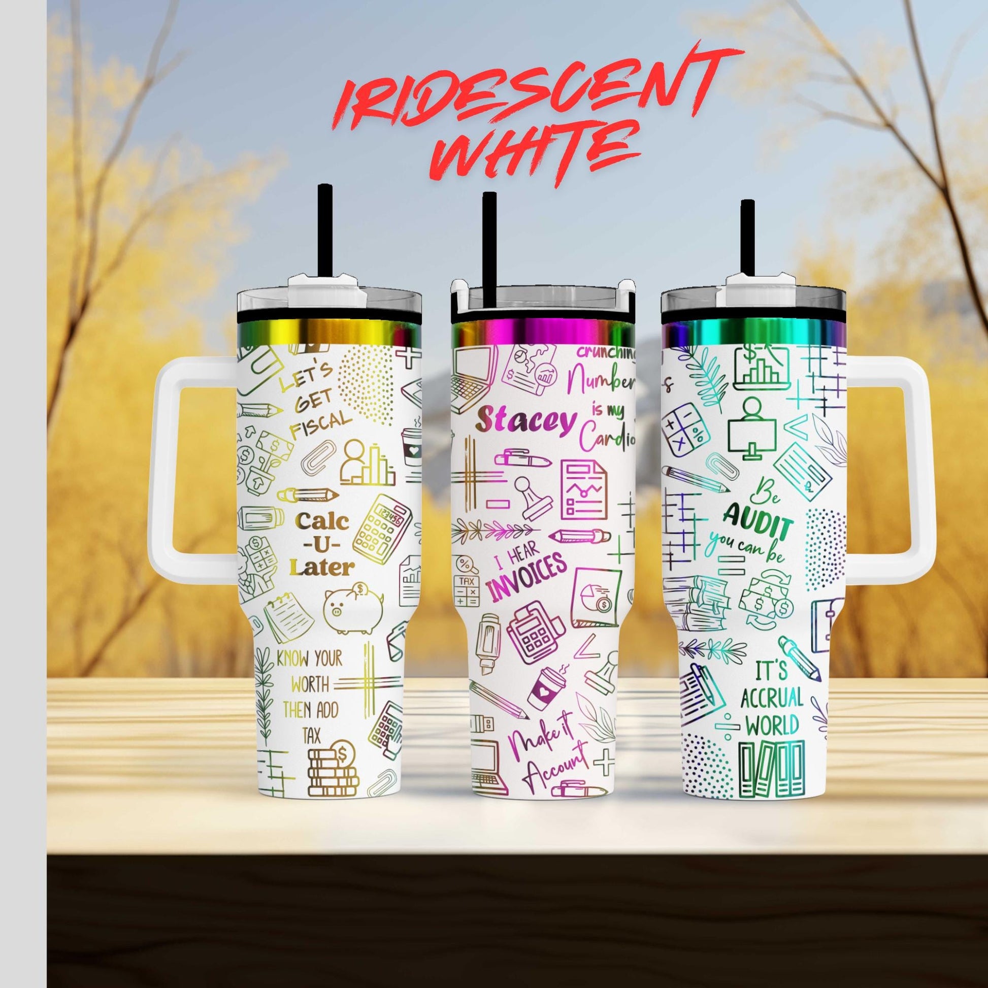 Three colorful tumblers with various text and graphics printed on them, placed on a wooden surface against a blurred background.