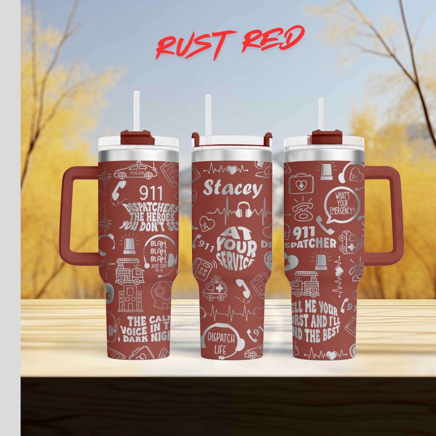 three red tumblers with various text and graphics printed on them, set against a blurred background of trees and a blue sky.
