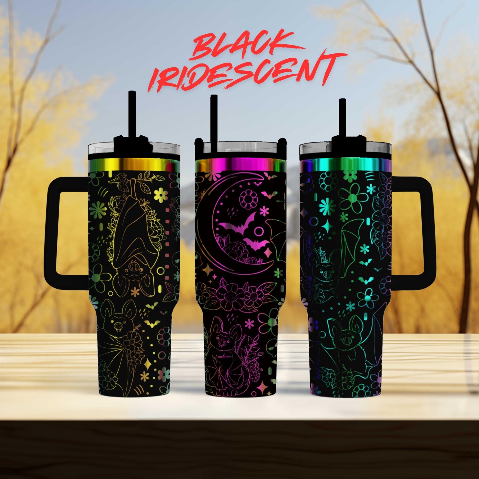 three colorful, patterned tumblers with handles, arranged in a row on a wooden surface.