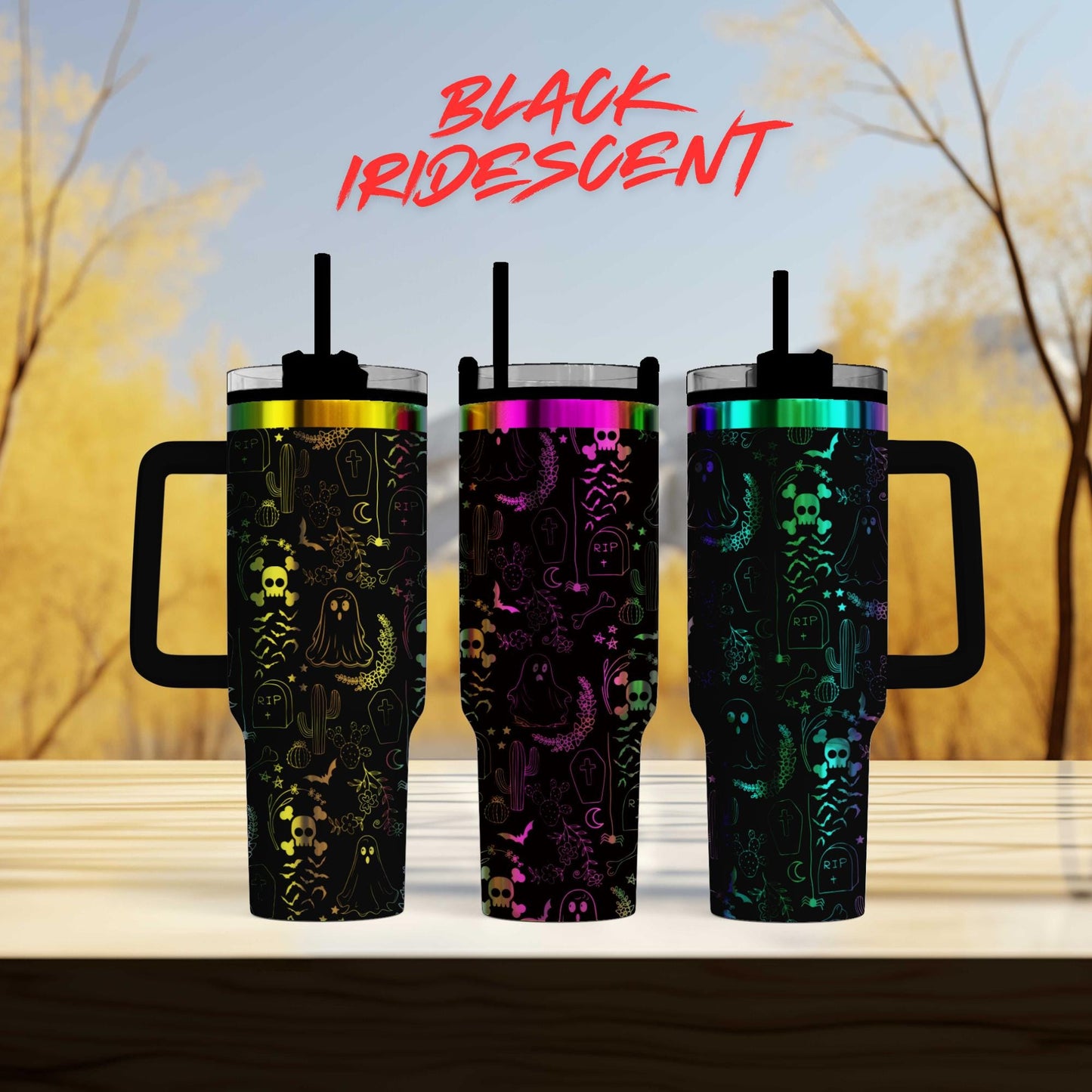 three colorful, patterned insulated tumblers with handles, arranged in a row on a wooden surface against a blurred background of trees.