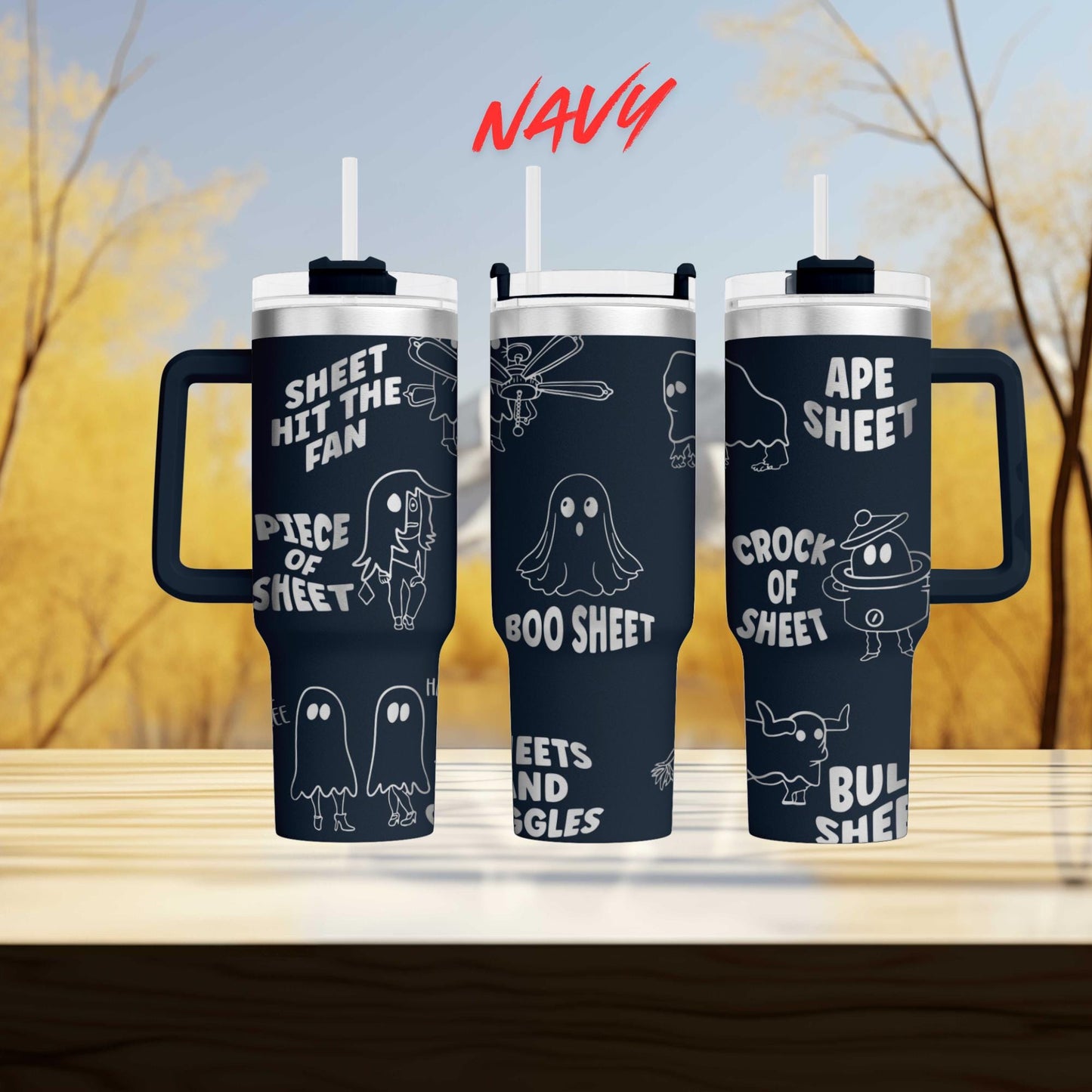 three black tumblers with white text and illustrations on them, set against a blurred background of trees.