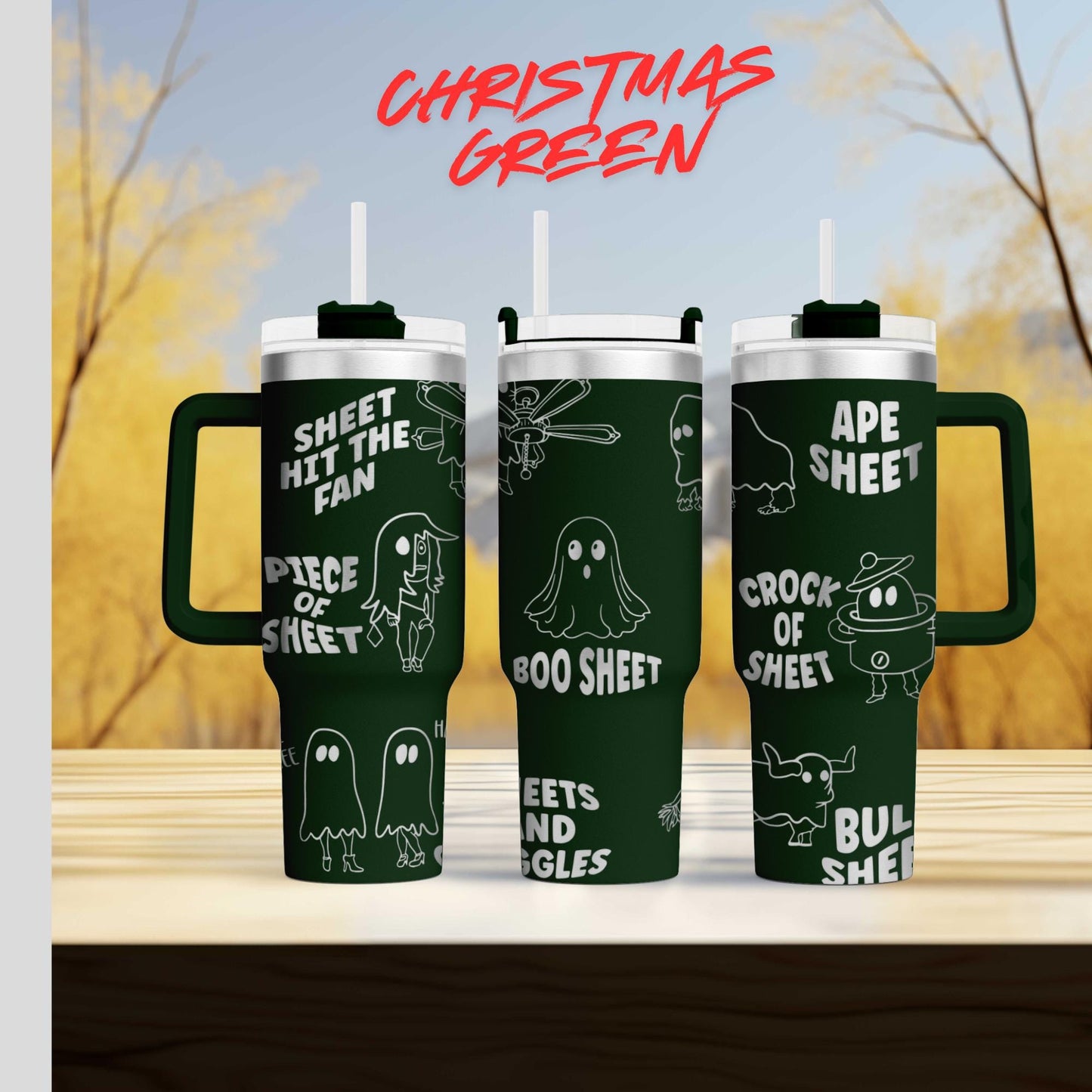 three green tumblers with white text and illustrations on them, set against a blurred background of trees and sky.