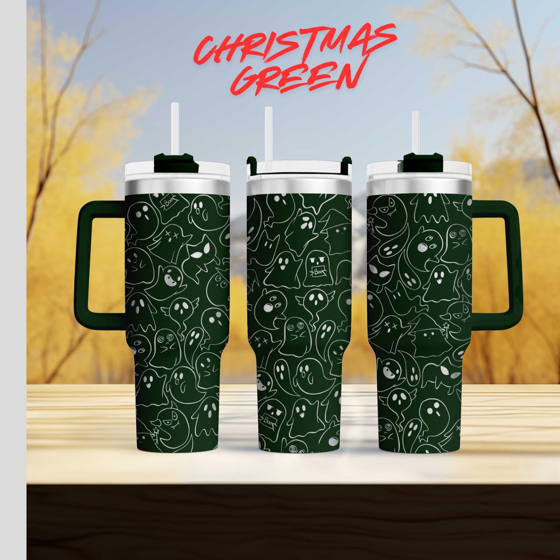 three green tumblers with a pattern of white ghost-like figures on them, set against a blurred background of trees and a blue sky.