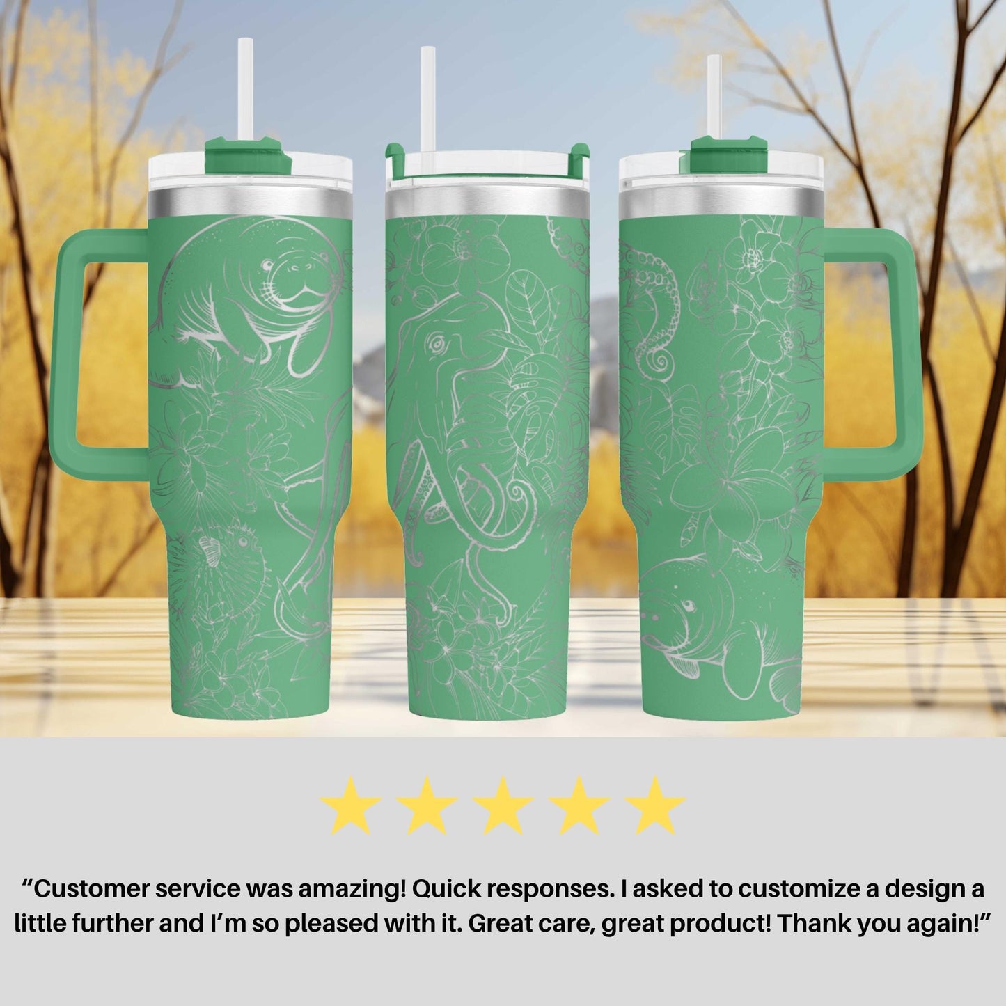 three green tumblers with white designs, including fish and plants, placed on a wooden surface against a blurred background of trees.