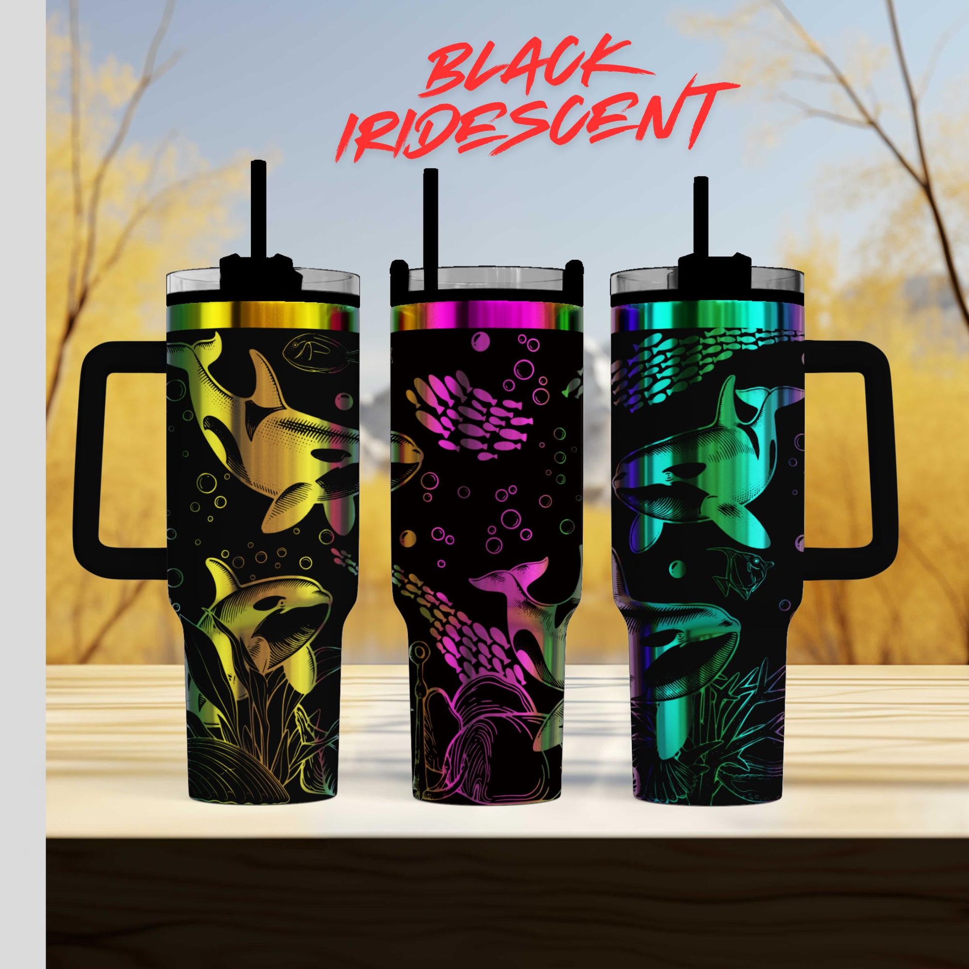 three colorful tumblers with fish designs, including a black and purple tumbler, a green and purple tumbler, and a black and purple tumbler, all with handles and straws.