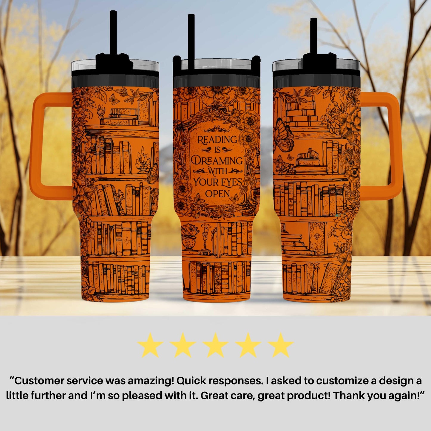 three orange tumblers with a design of books and a butterfly on them, placed on a table against a blurred background of trees.