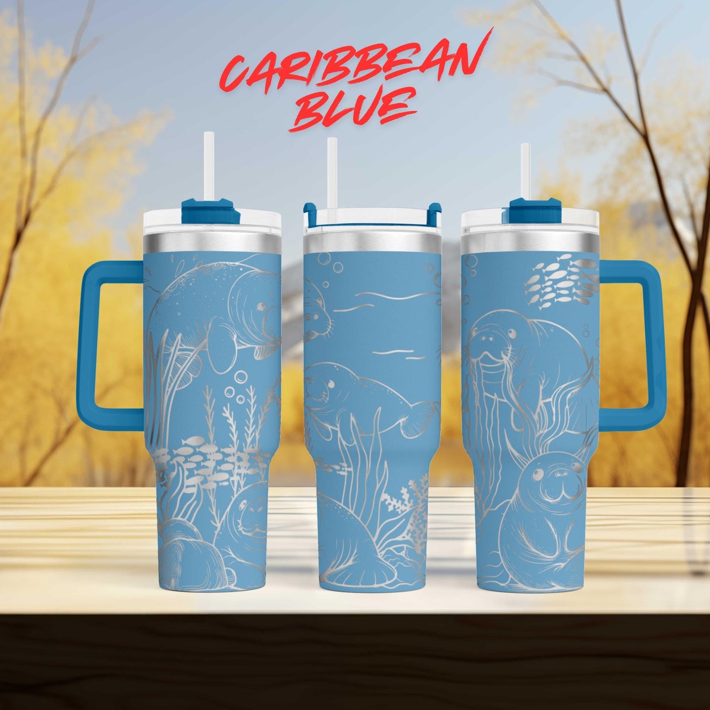 three blue tumblers with illustrations of marine life, including fish, sea creatures, and plants, against a blurred background of trees and sky.