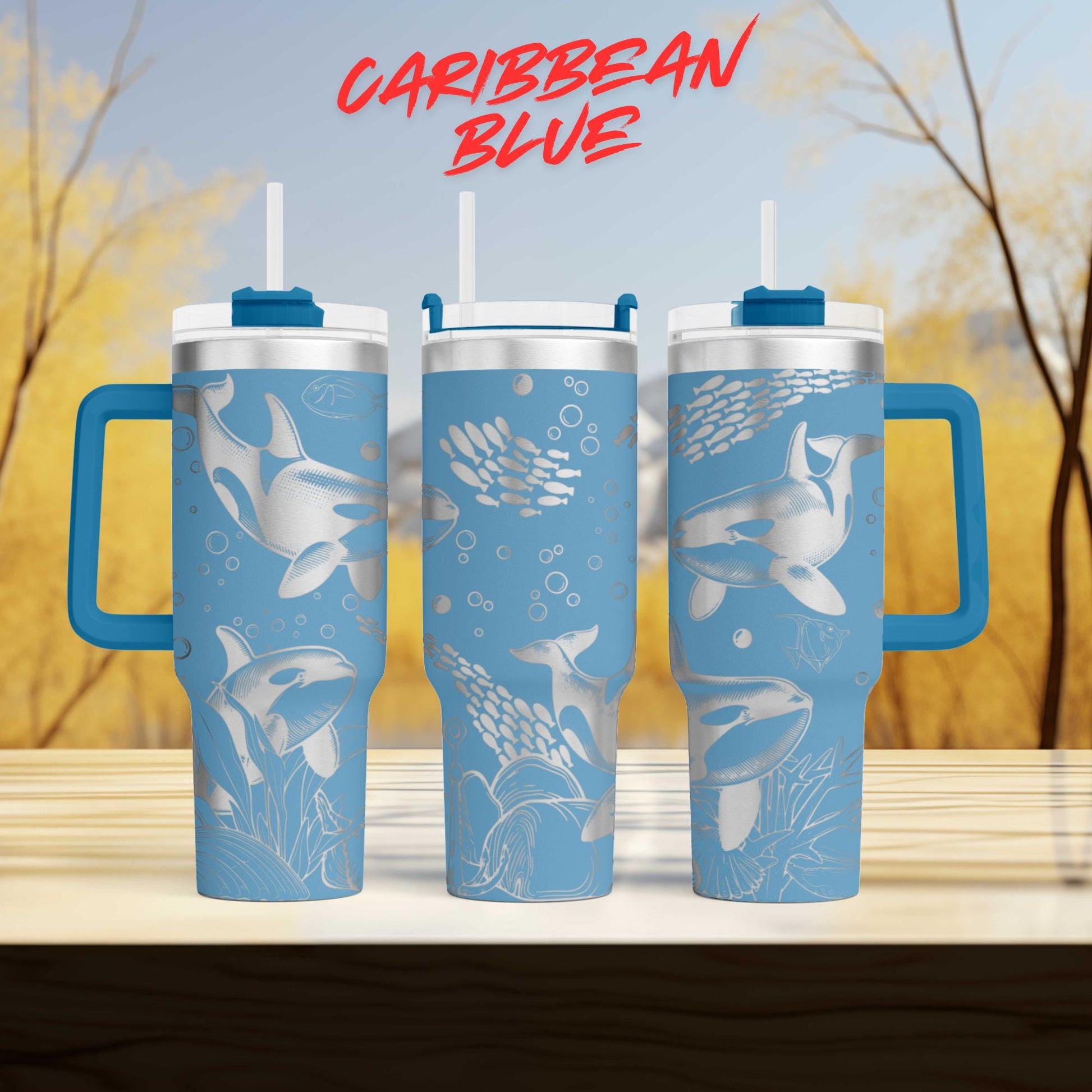 three blue tumblers with a design of marine life, including sharks and bubbles, printed on them.