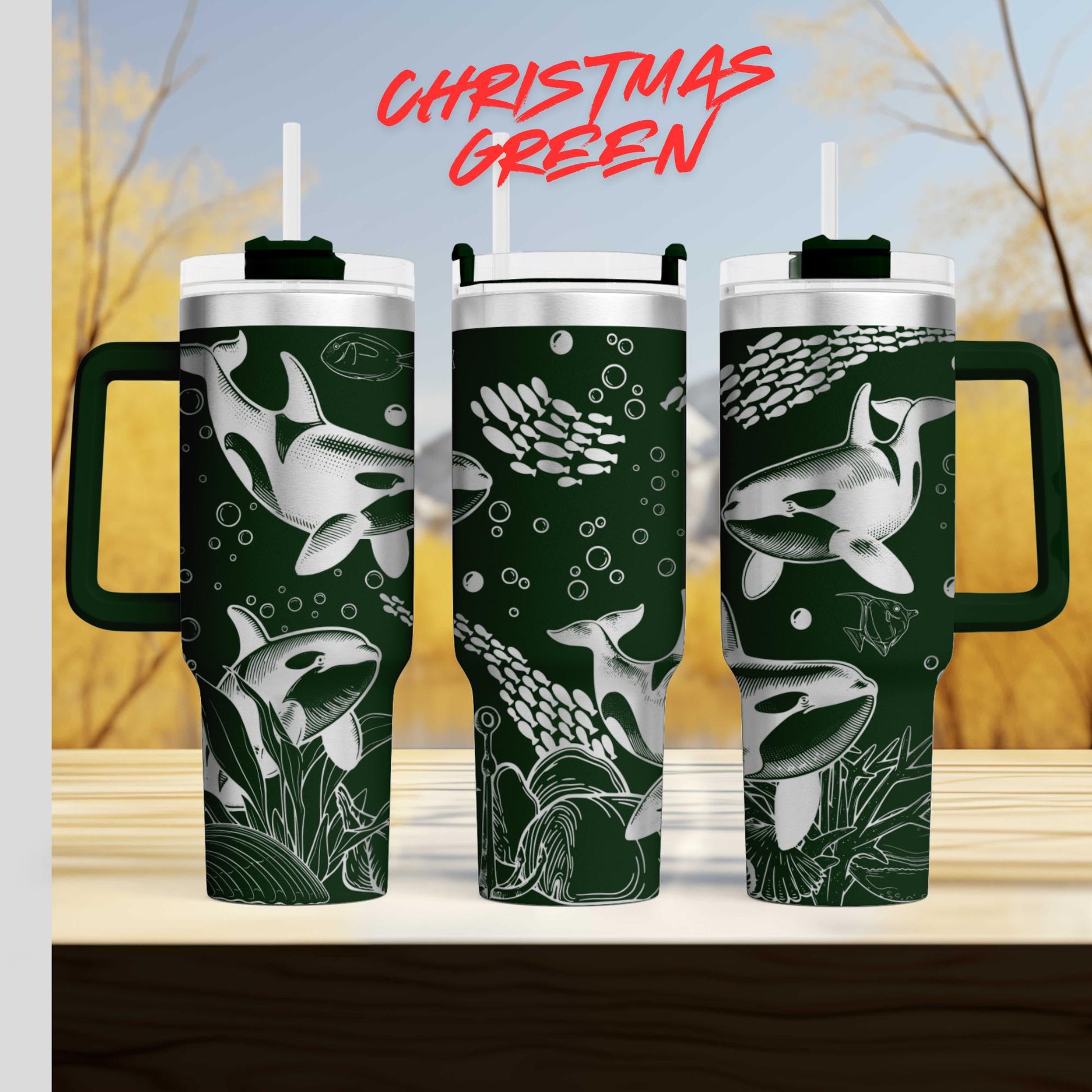 three green tumblers with white and black designs depicting marine life, such as fish and bubbles, against a blurred background of trees and sky.