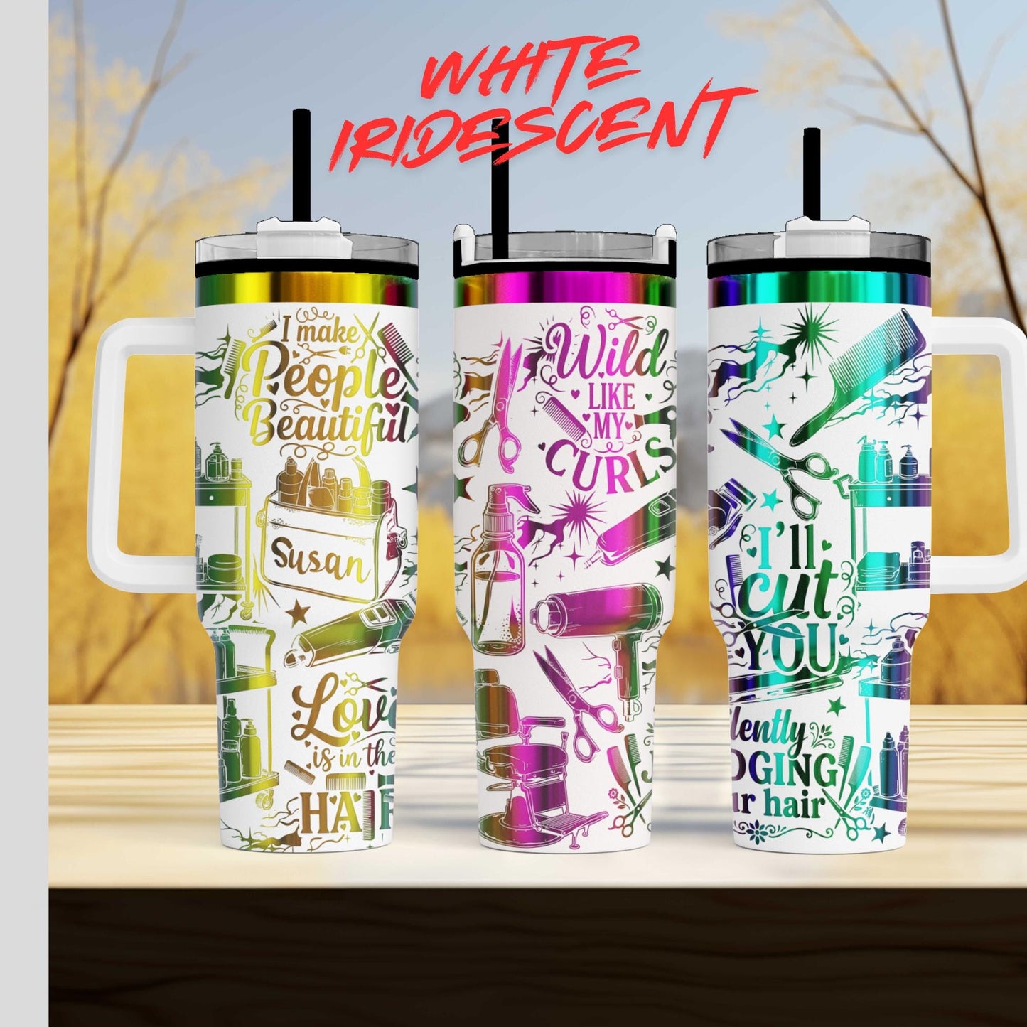 three colorful tumblers with various designs and text on them, placed on a wooden surface against a blurred background.