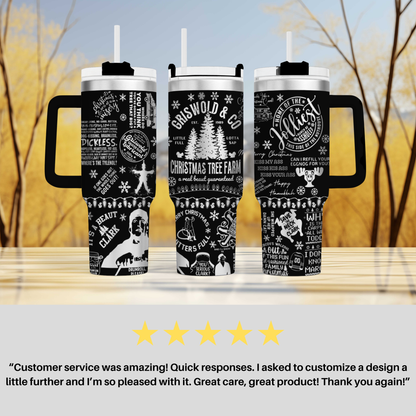 three black and white tumblers with various text and graphics printed on them, placed on a wooden surface against a blurred background of trees.