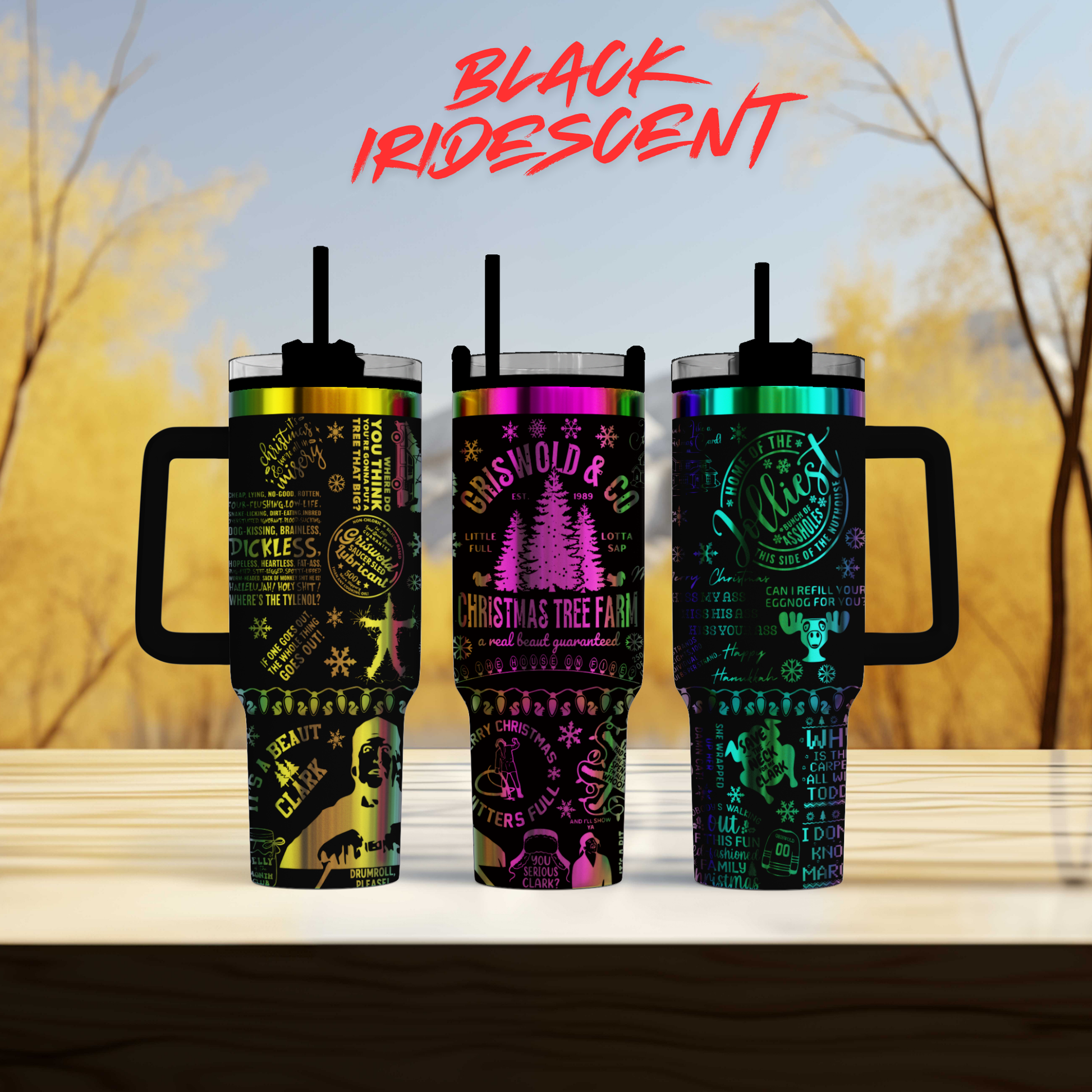 Three colorful tumblers with text and graphics printed on them, set against a blurred background of trees.