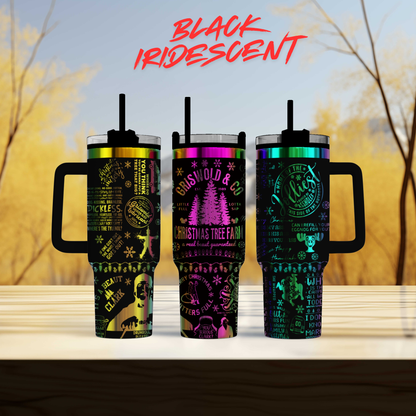 Three colorful tumblers with text and graphics printed on them, set against a blurred background of trees.