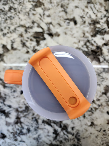 a close up of an orange plastic object on a marble surface