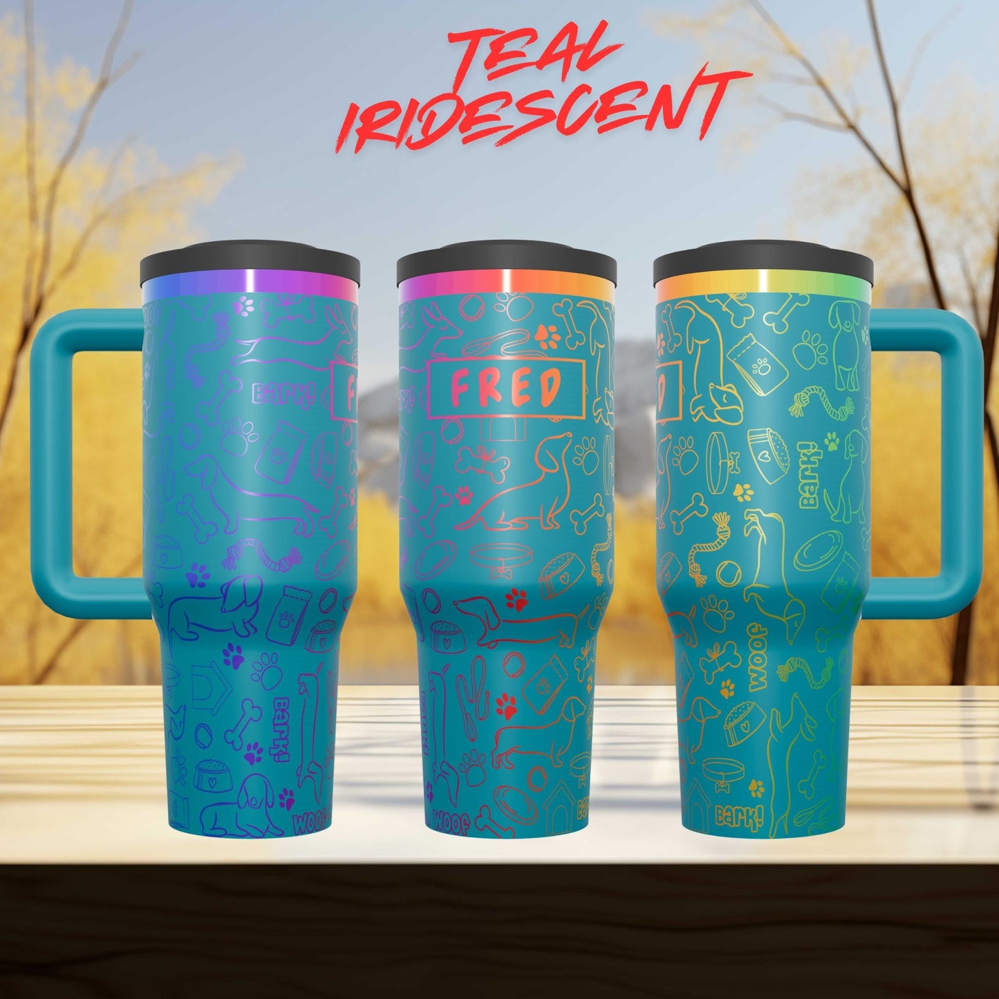 three colorful teal-colored mugs with various designs and text on them, placed on a wooden surface against a blurred background of trees.