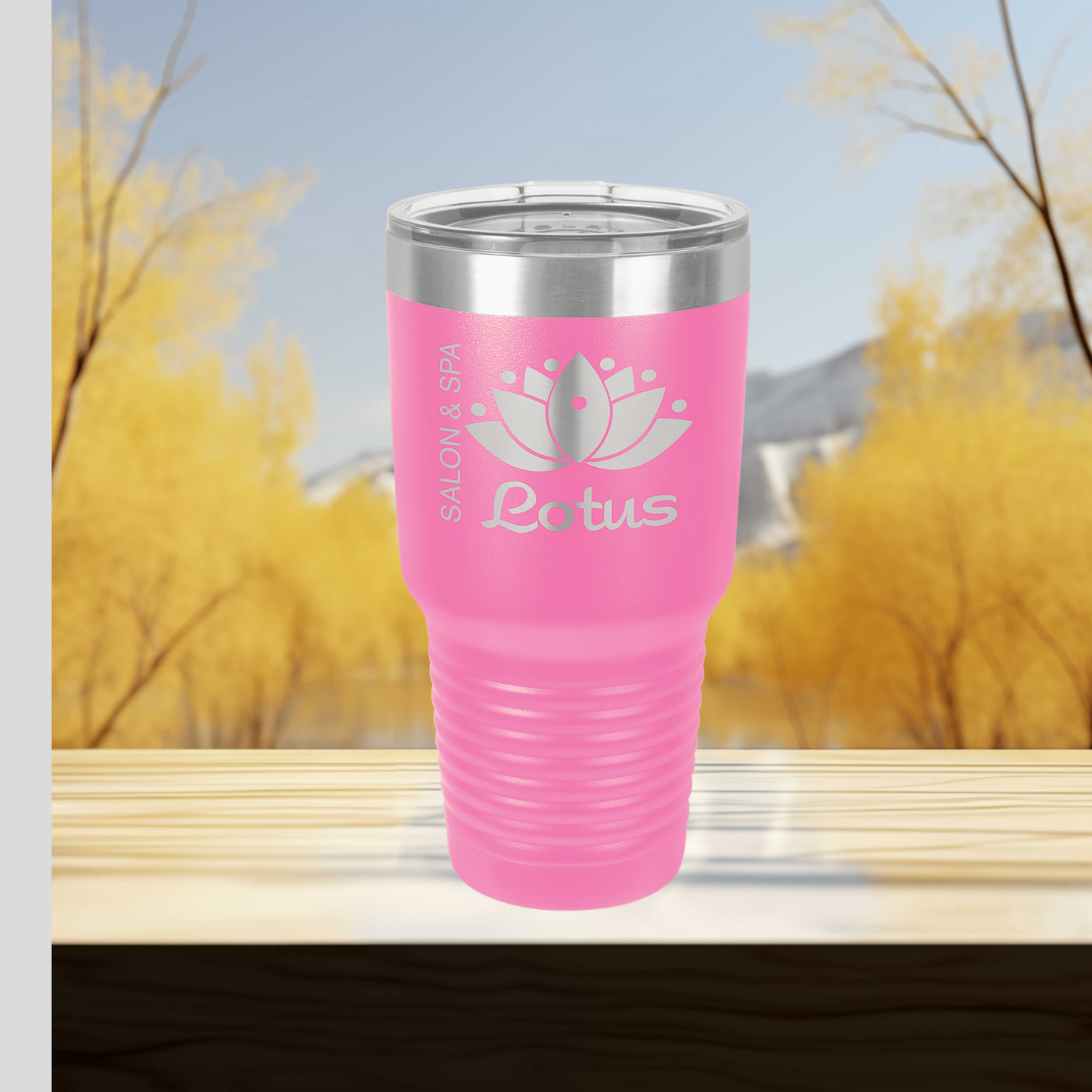 a pink tumbler cup sitting on top of a wooden table