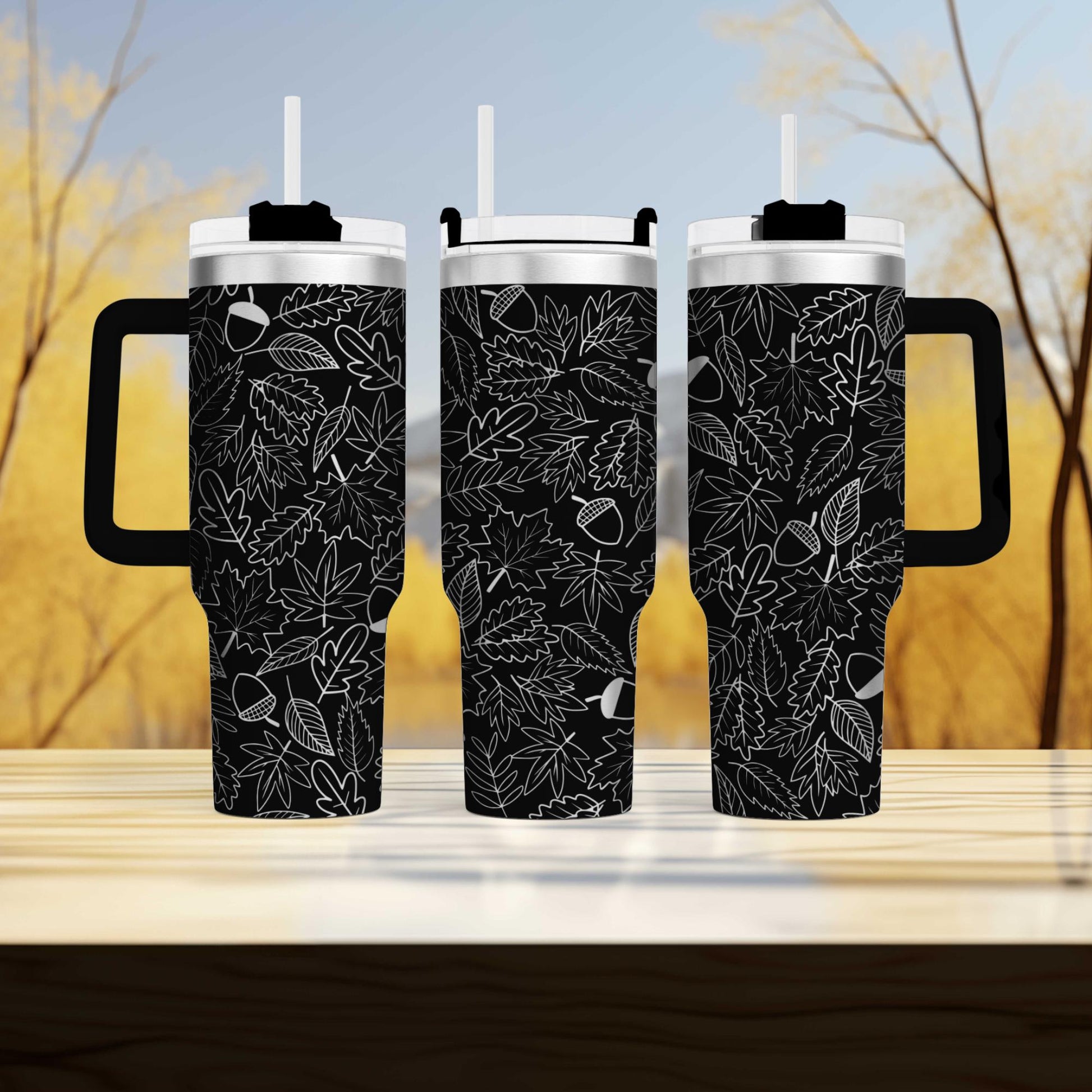 two black coffee mugs sitting on top of a wooden table