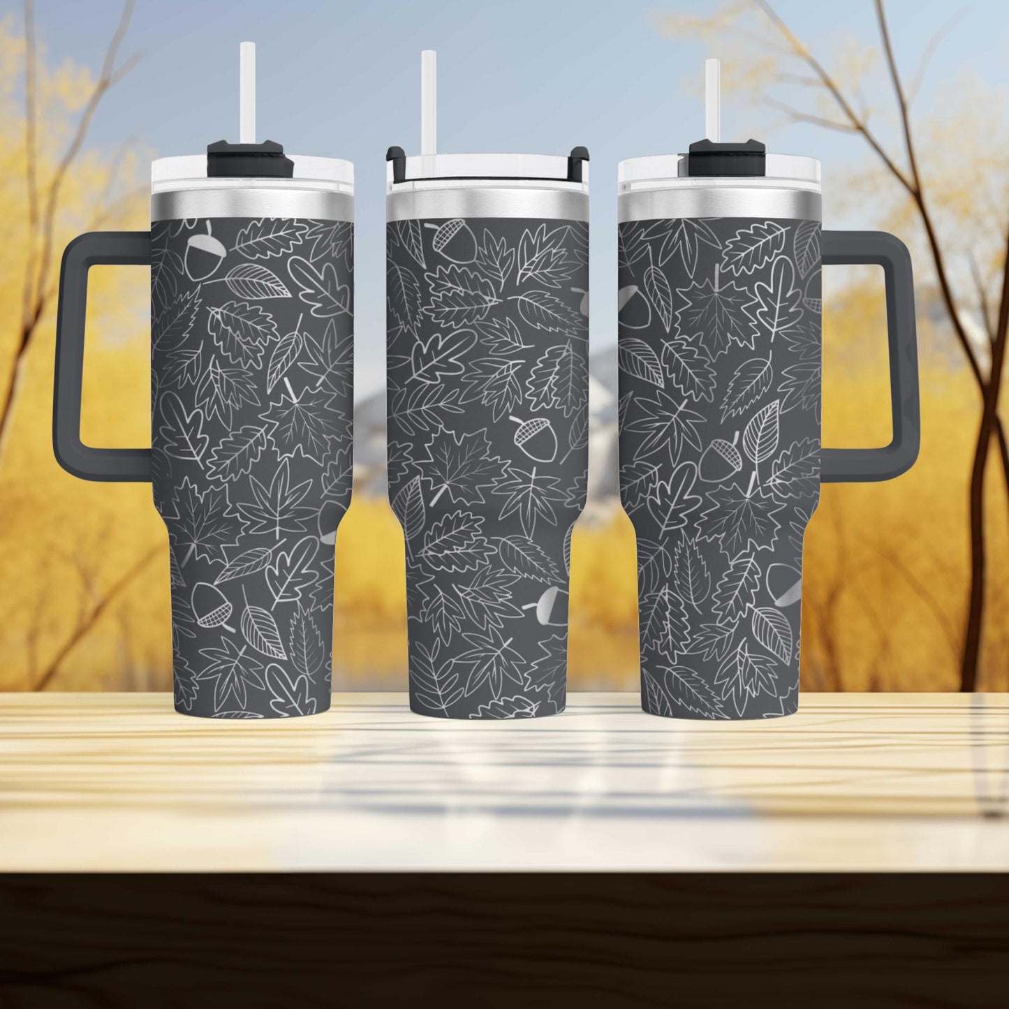 three travel mugs sitting on top of a wooden table