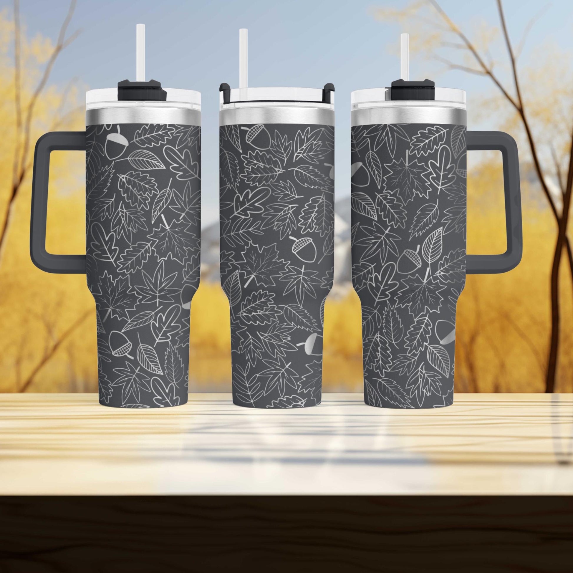three travel mugs sitting on top of a wooden table