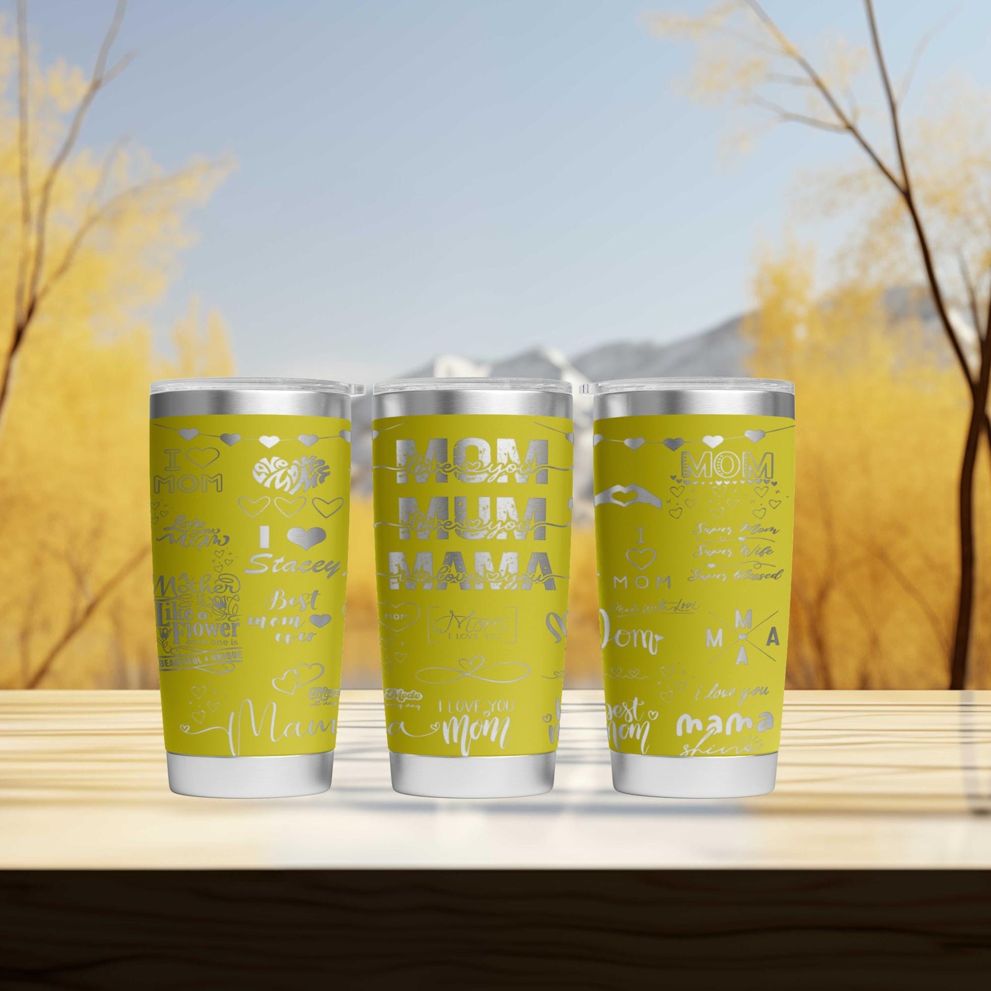 three cans of soda on a table with trees in the background