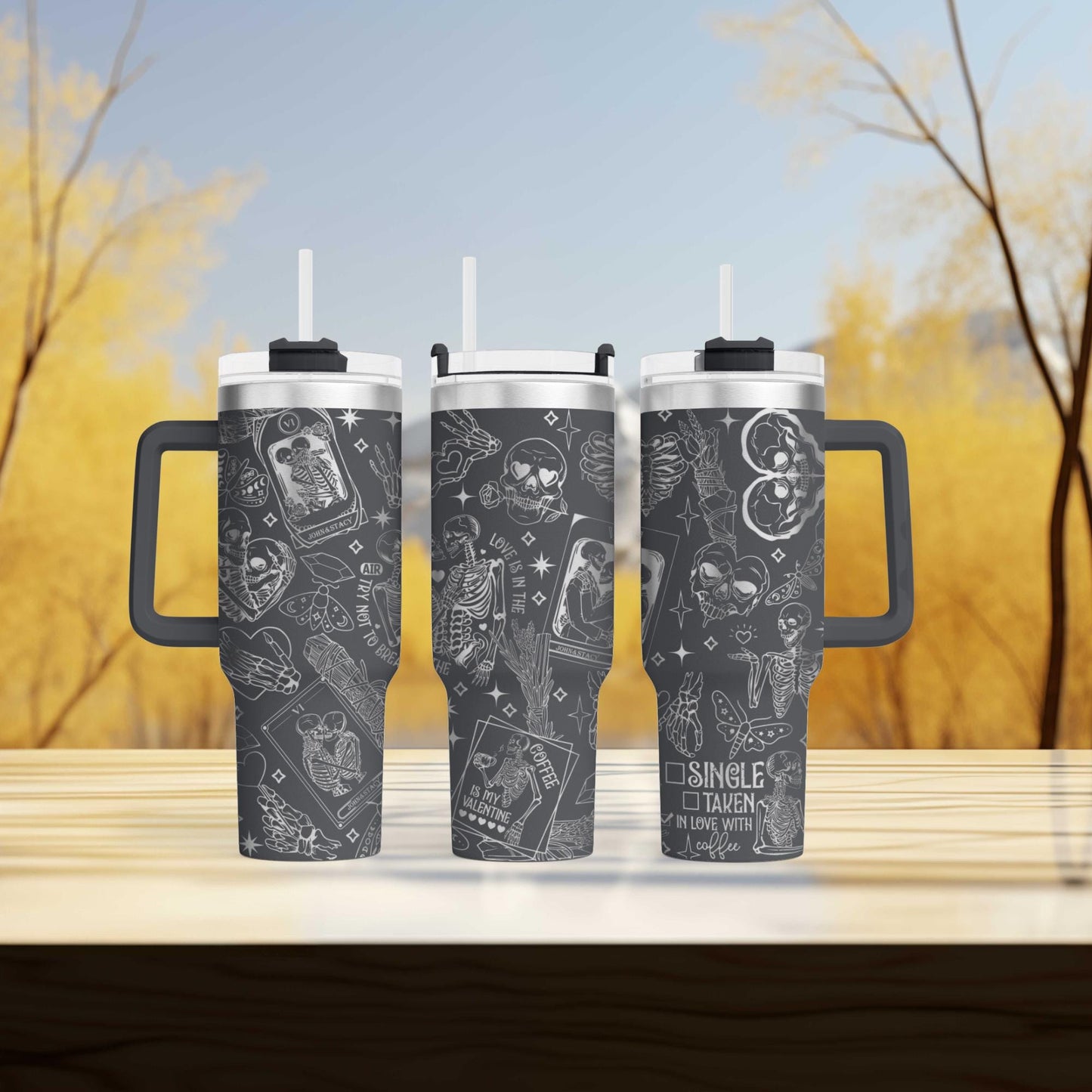 three travel mugs sitting on top of a wooden table