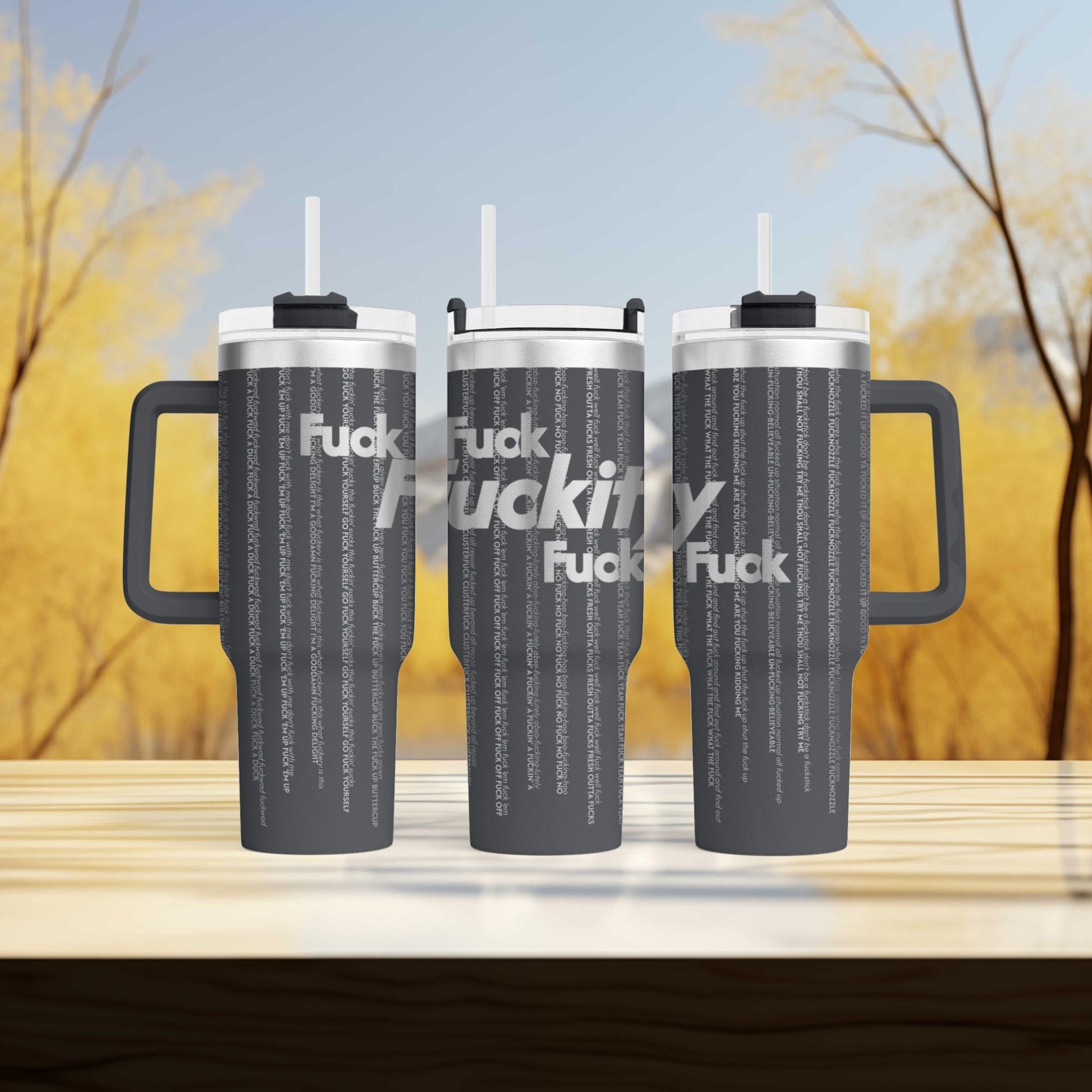 a couple of travel mugs sitting on top of a wooden table