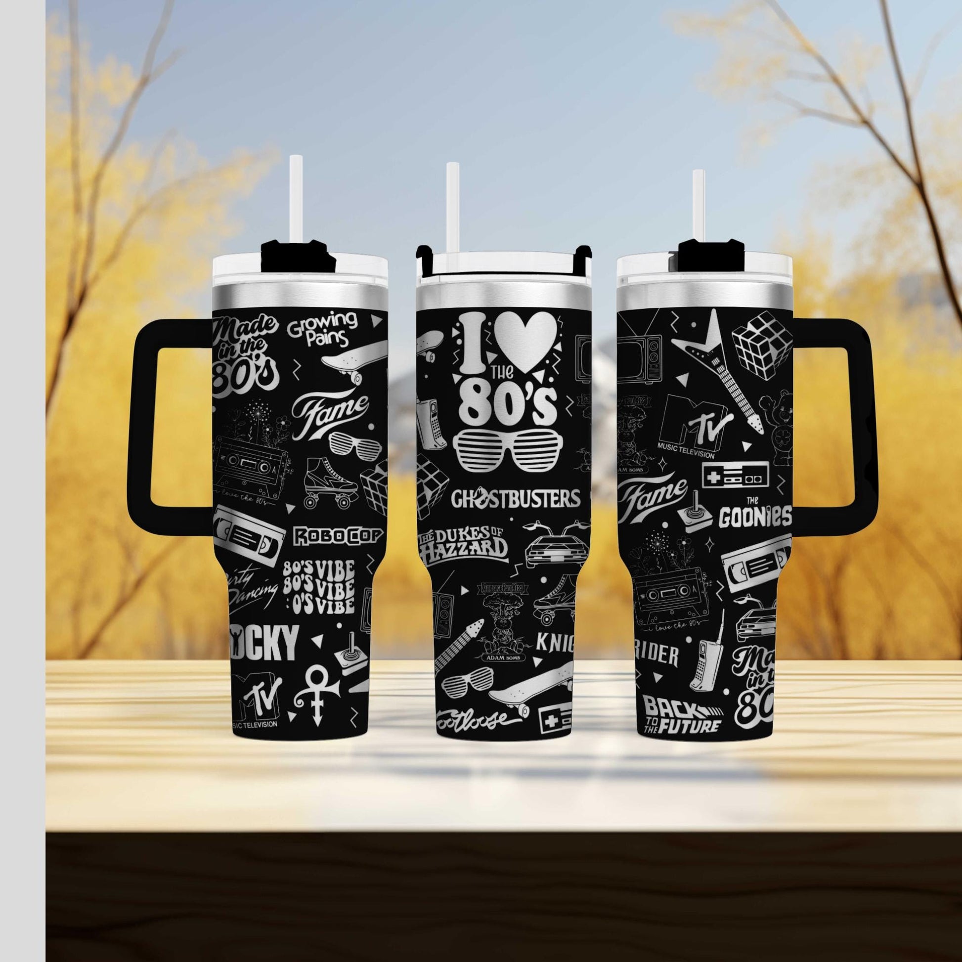 two travel mugs sitting on top of a wooden table