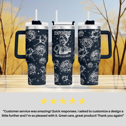 two travel mugs sitting on top of a table