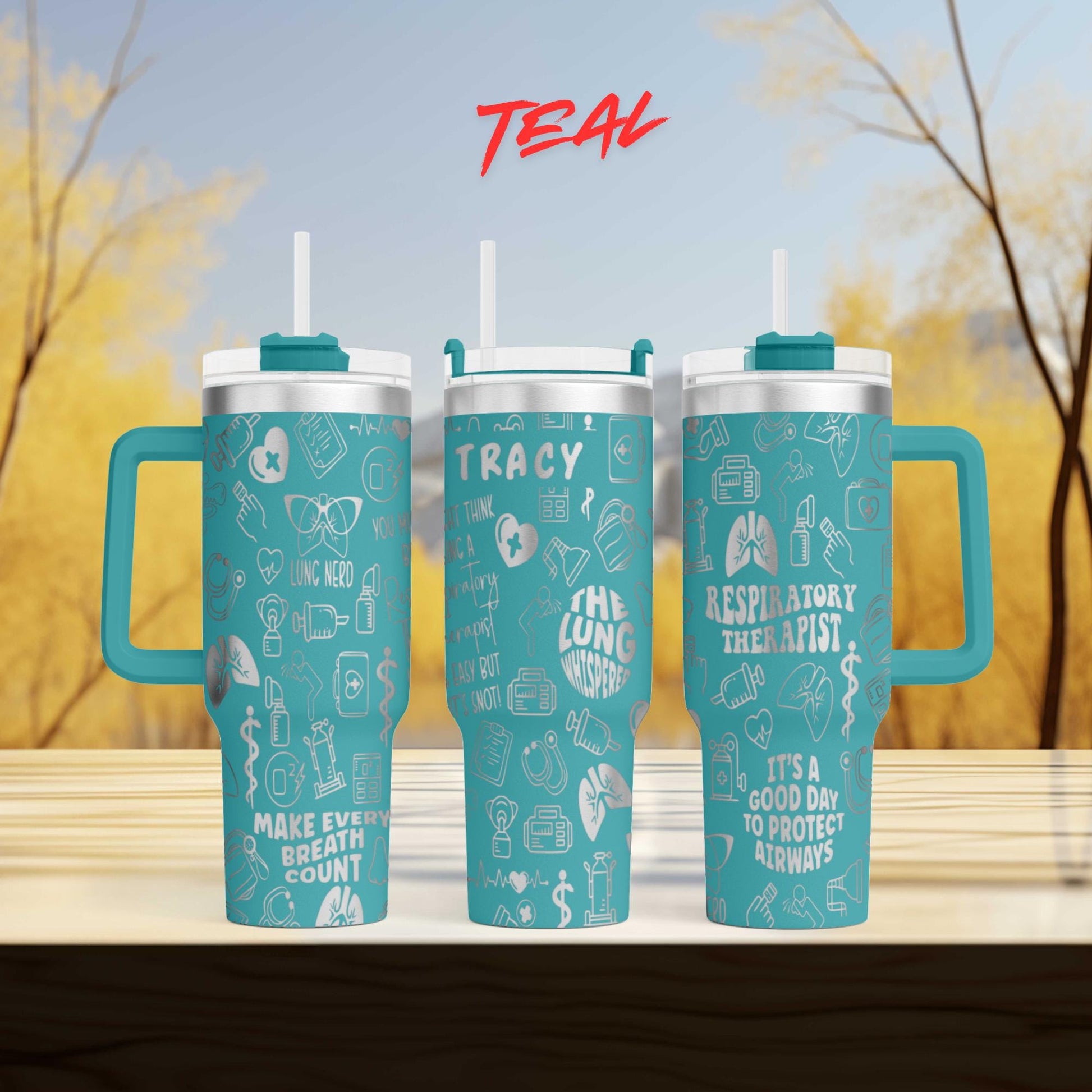 three teal travel mugs sitting on top of a wooden table