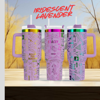 Three colorful stainless steel tumblers with various designs and text printed on them, placed on a wooden surface against a blurred background.