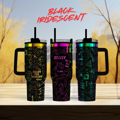 three colorful, patterned tumblers with handles, set against a blurred background of trees.