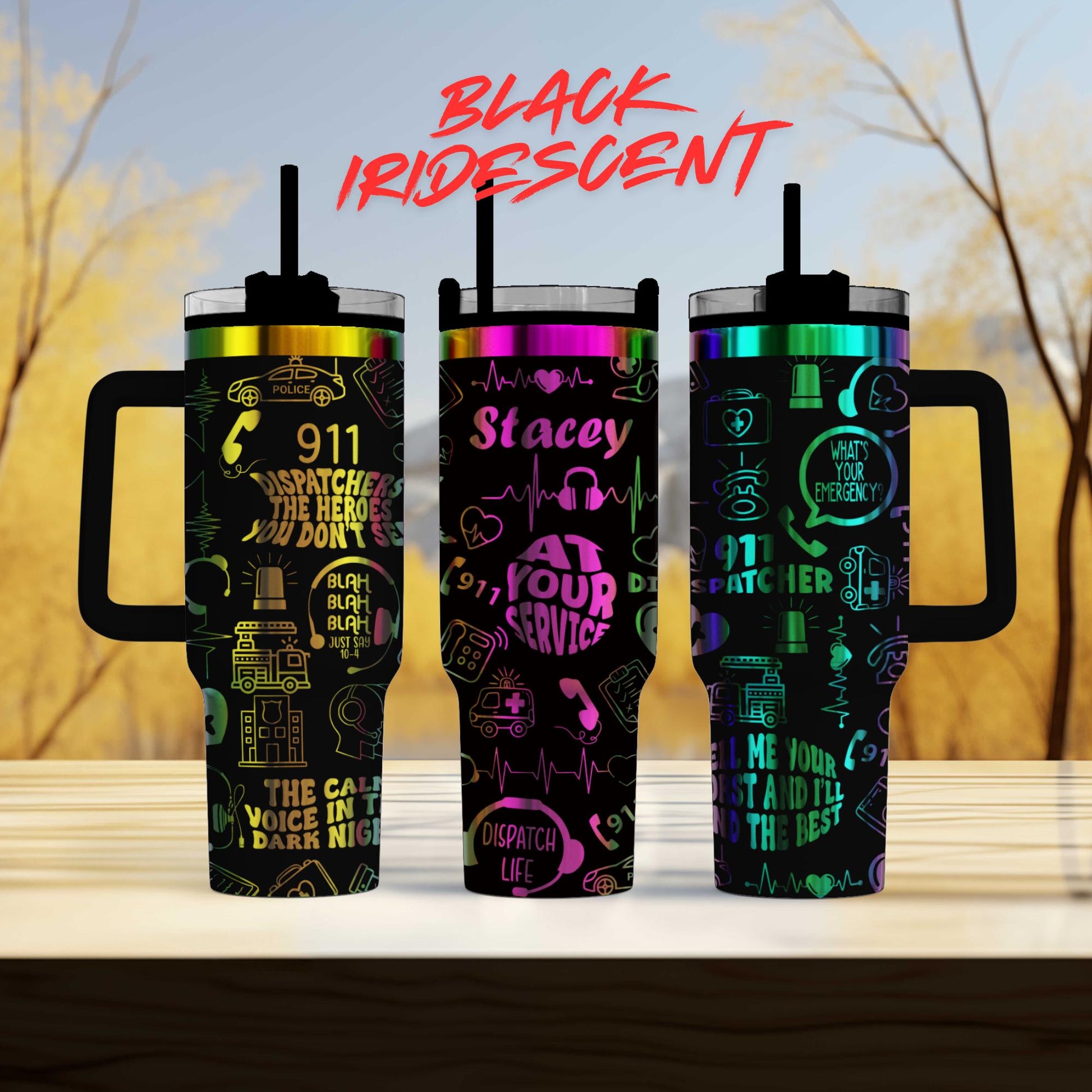 three colorful tumblers with various designs and text on them, placed on a wooden surface against a blurred background.