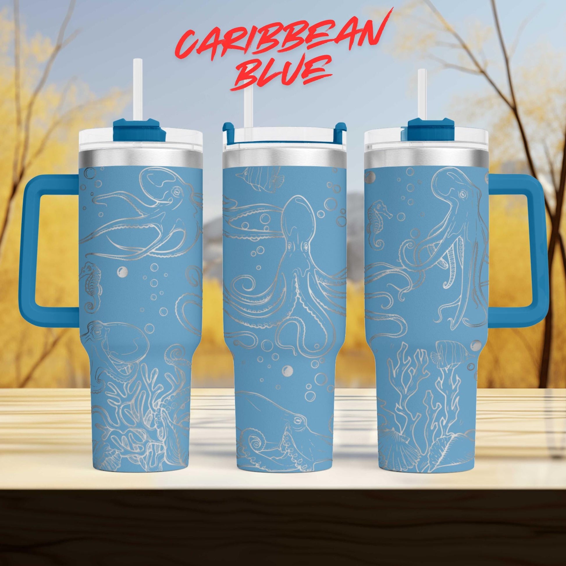 three blue tumblers with white designs depicting marine life, such as octopuses and bubbles, against a blurred background of trees and sky.