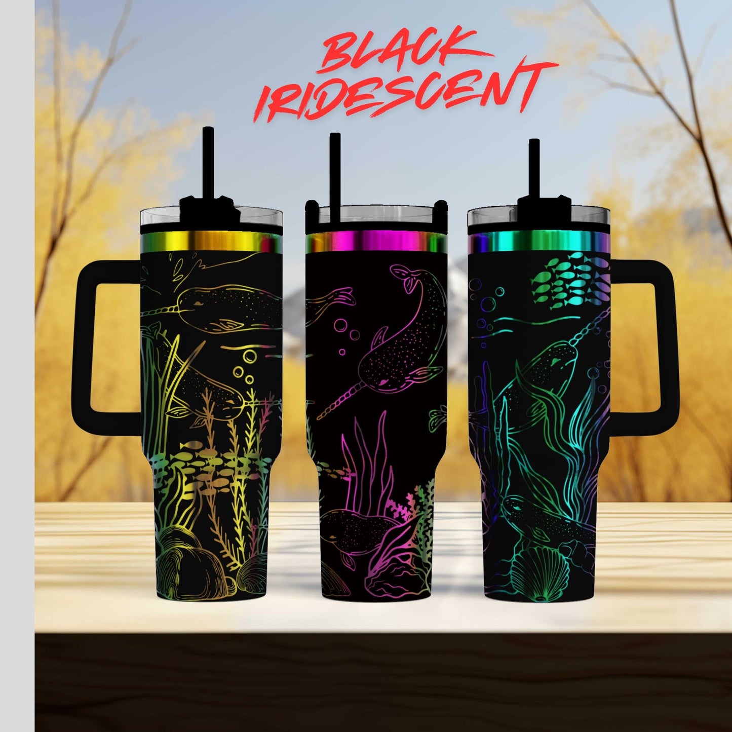 Three colorful, patterned tumblers with handles, featuring marine life designs, are displayed against a blurred natural background.