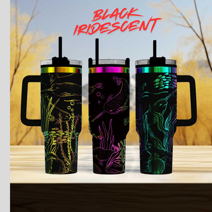 Three colorful, patterned tumblers with handles, featuring marine life designs, are displayed against a blurred natural background.